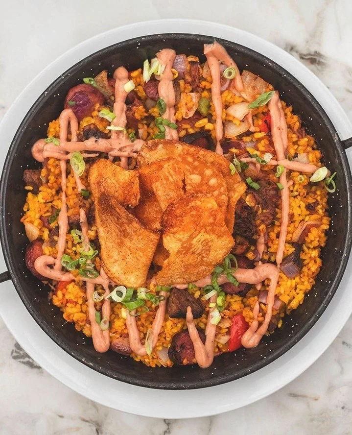 Not your traditional paella&mdash;and that's exactly the point.⁠
⁠
Our BACKYARD BBQ PAELLA brings together beef brisket, pulled pork, grilled wagyu hot dog, sweet corn, peppers, onions, charred tomato BBQ broth, BBQ crema, and crunchy house-spiced po