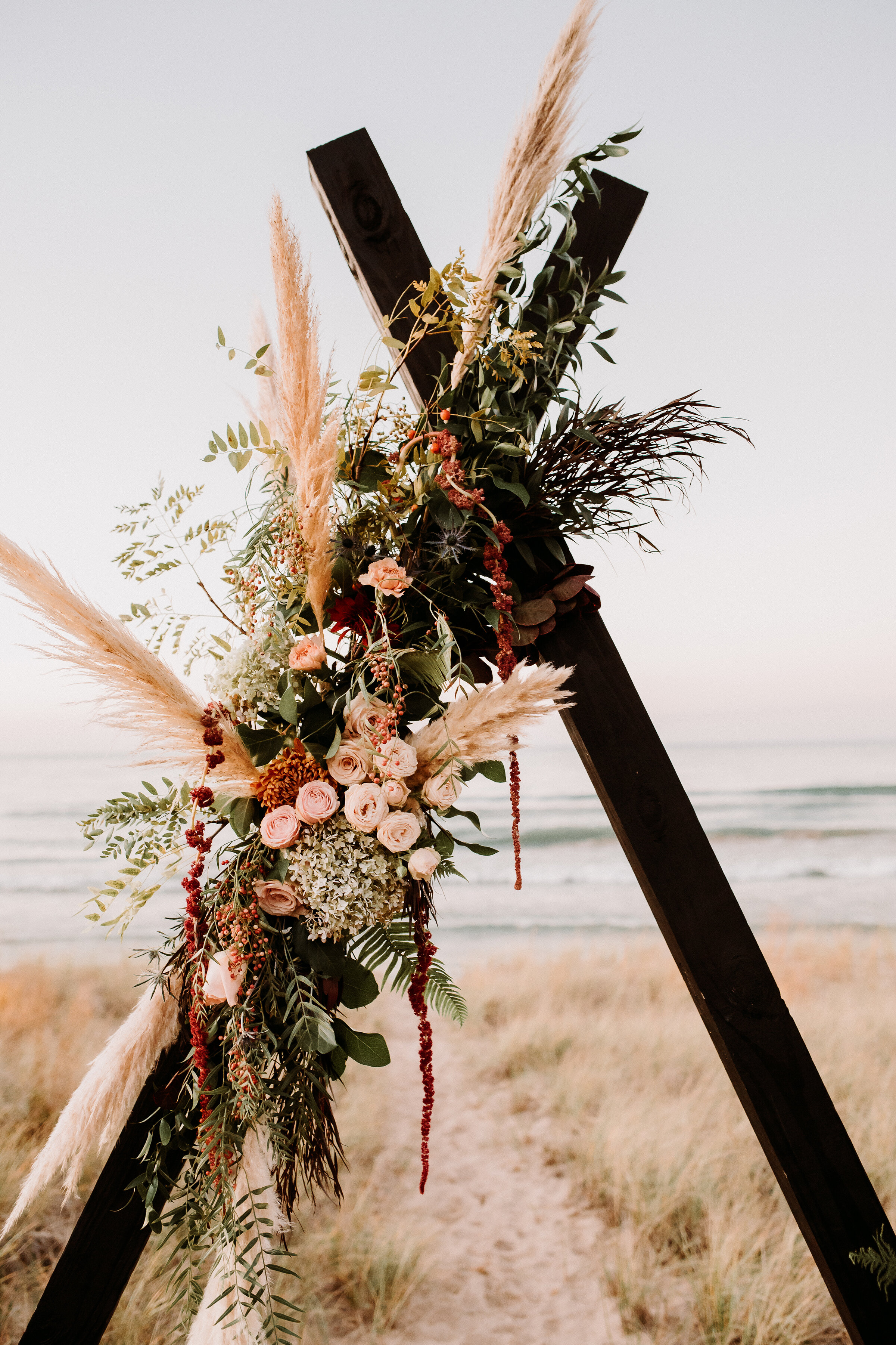  Beautiful bohemian floral decorated black wedding arch for an adventurous styled elopement shoot in Indiana Dunes State Park. Indiana wedding photographer midwest elopement on the shores of lake Michigan Valparaiso elopement photography beach styled