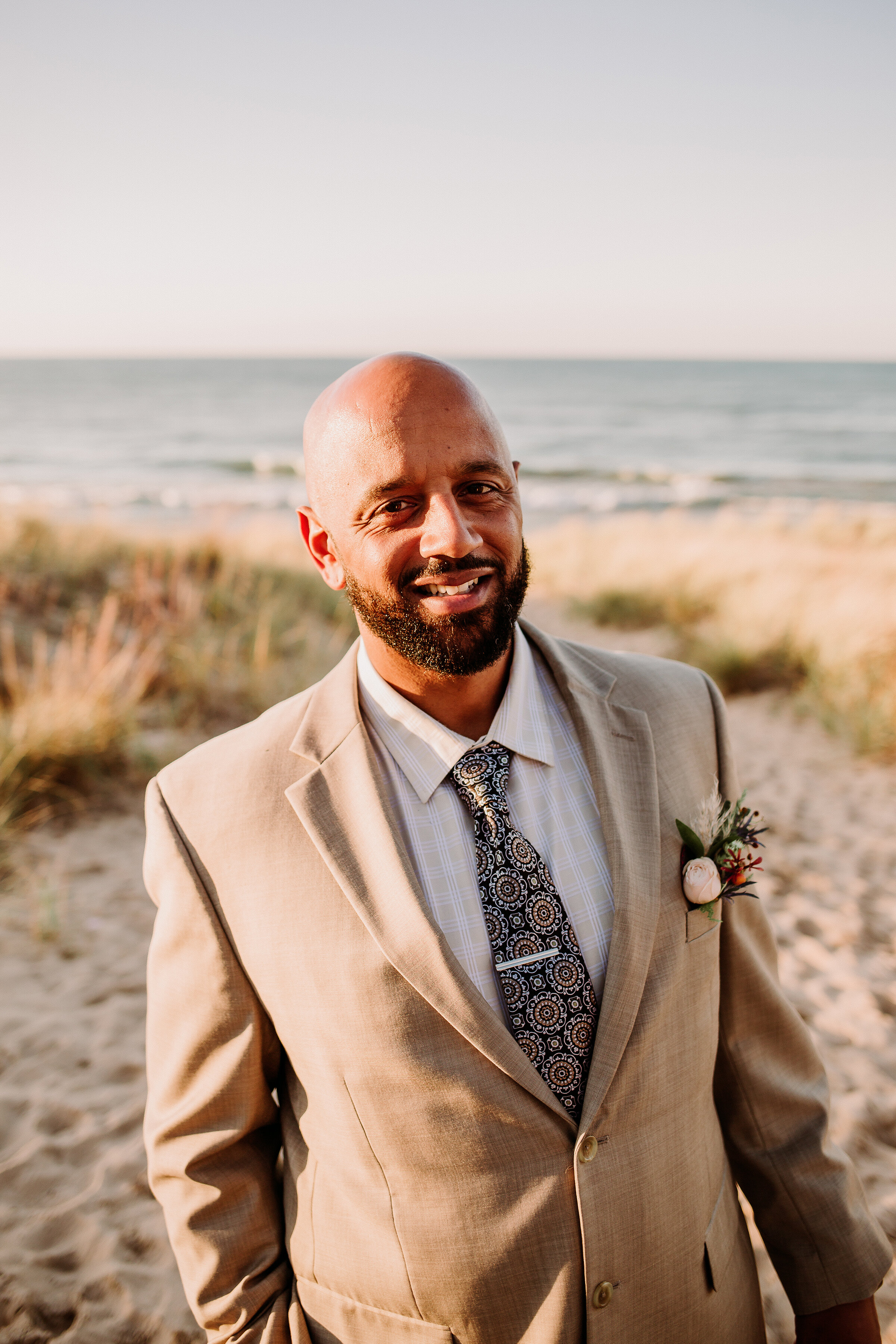  Groom to be styled for this boho elopement shoot on the shores of Lake Michigan in Indiana Dunes State Park. Groom to be tan suit boho chic tie boho boutonniere Lake Michigan beach wedding elopement photography beach styled shoot Valparaiso Indiana 