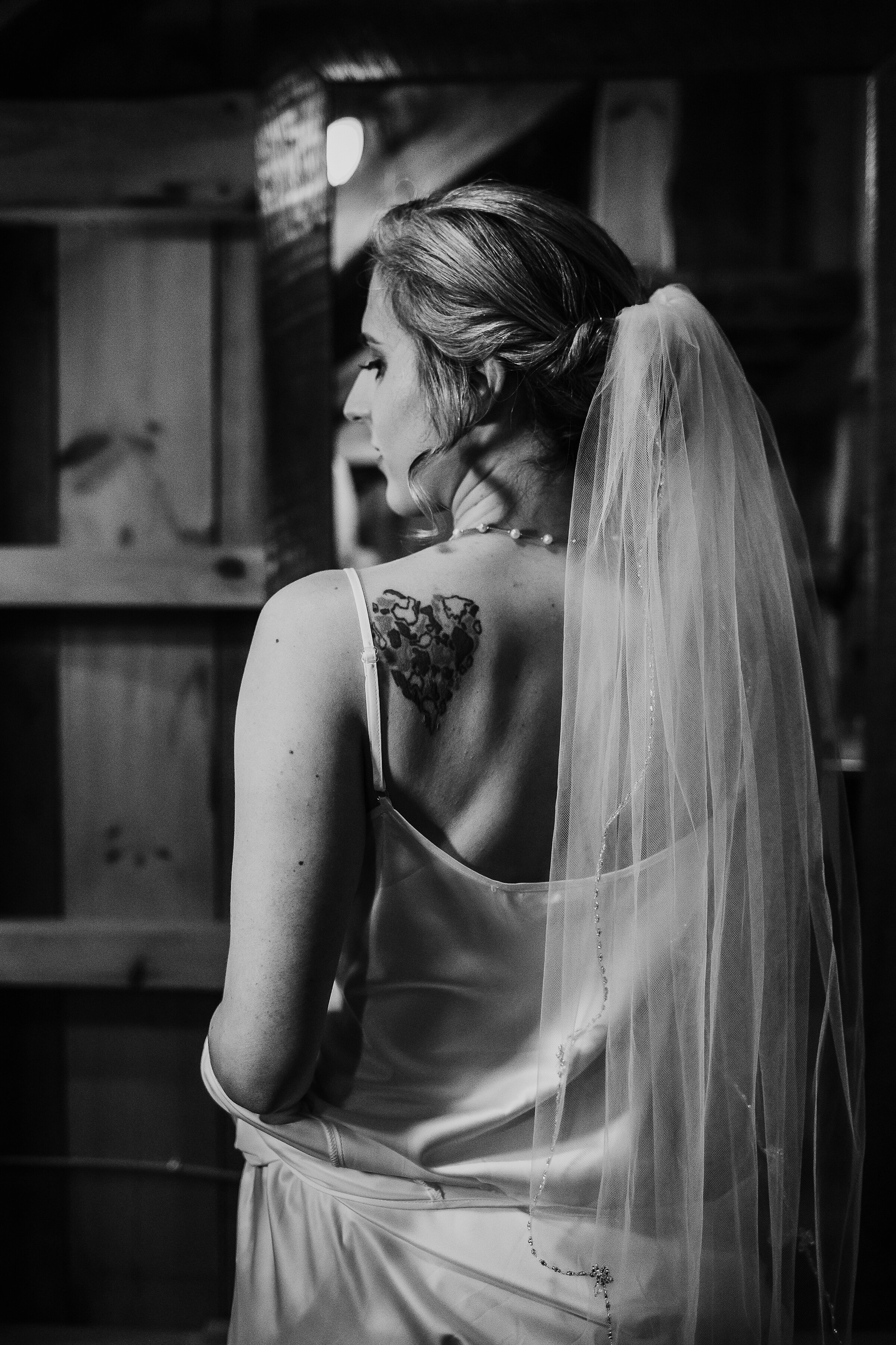  Moody natural lighting utilized by Kindred + Co. Photography highlights elegant bridal details on soon-to-be-bride’s wedding morning in Columbus, Ohio wedding. spaghetti strap wedding dress, hip length bridal veil, loose curled bridal updo, minimali