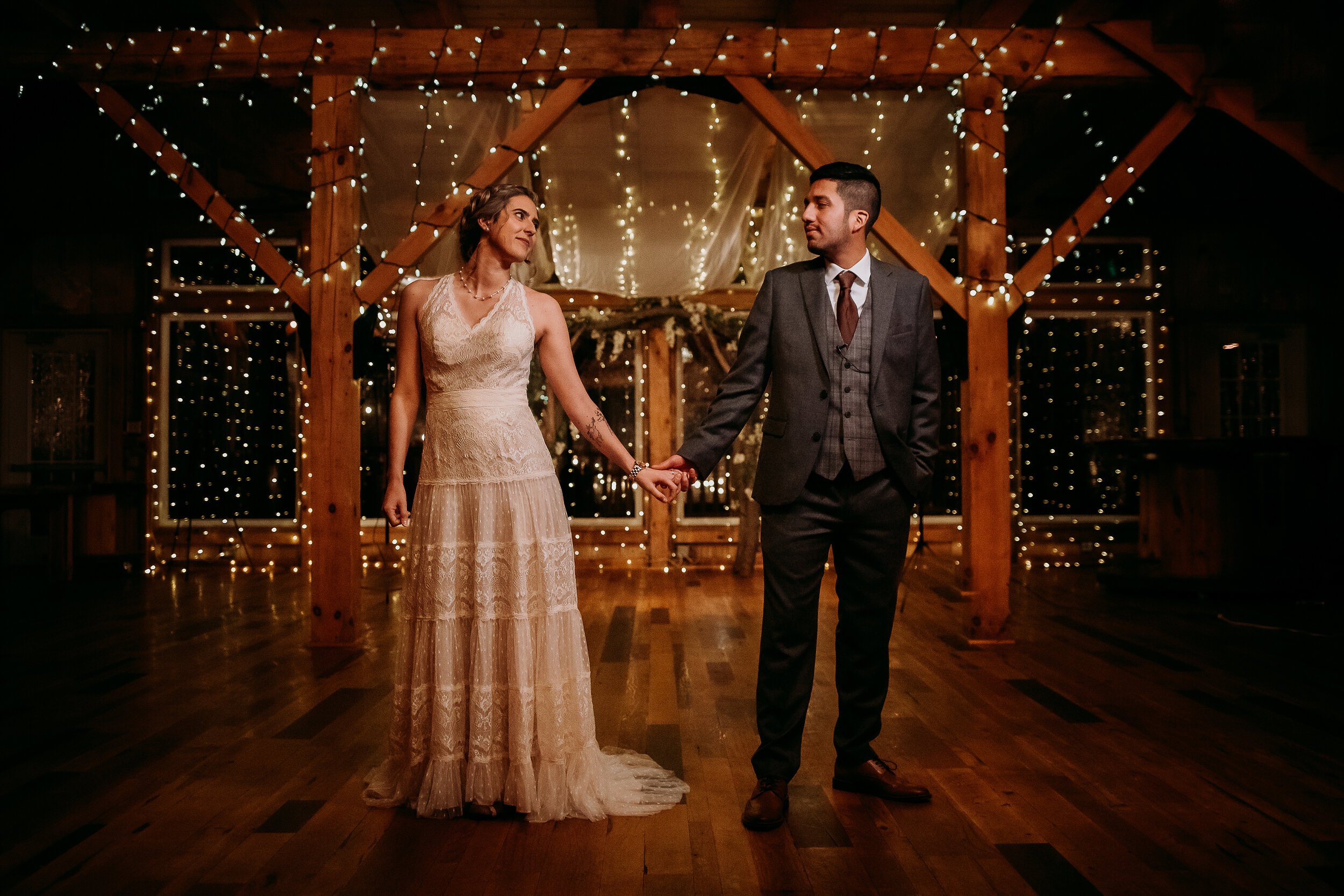  Kindred + Co. Photography captures romantic fairytale dancing following intimate evening treehouse elopement in Northeastern, Ohio. treehouse string lights, floral wooden wedding arch, bohemian wedding lace dress, braided bohemian wedding updo, hold