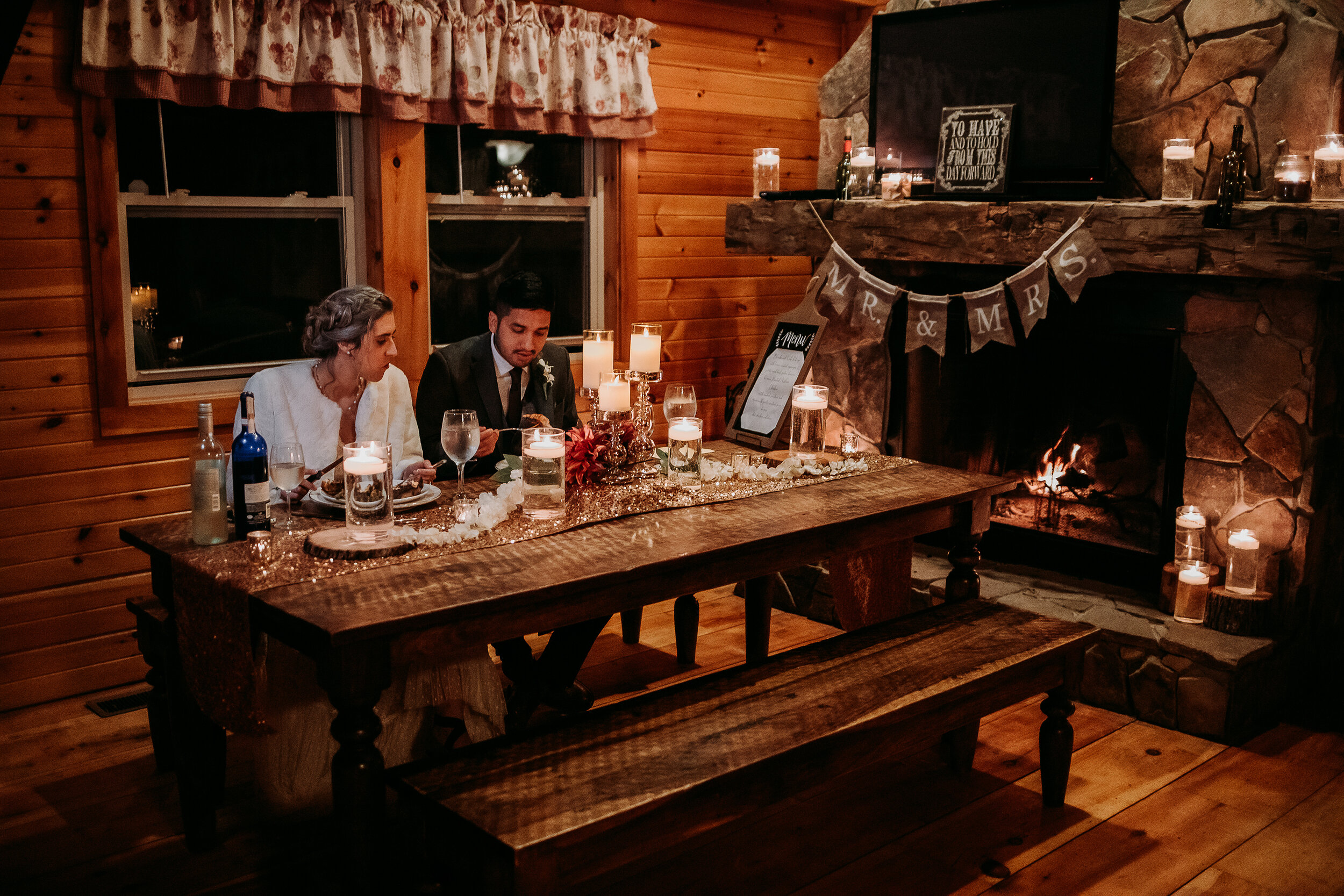  Kindred + Co. Photography captures newlyweds romantic elopement dinner by a wood burning fire in Colombus, Ohio. wood burning fire, wooden treehouse, treehouse elopement, candlelit wedding dinner, bohemian bride, moody evening light, professional co