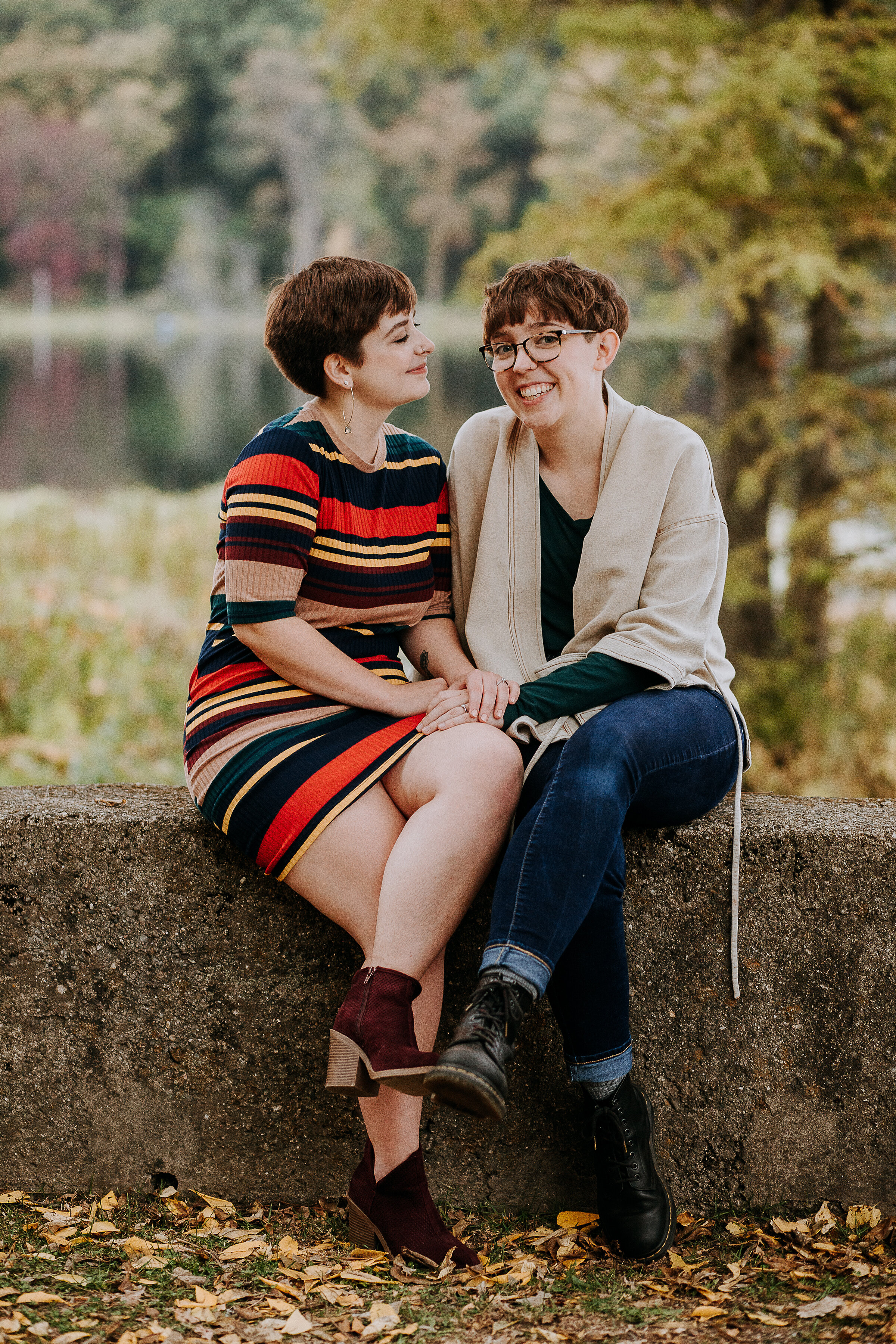  An adorable same-sex couple in fall outfits with stripes and boots and cardigans in this outdoor photoshoot by Kindred + Co. in Indiana. fall engagement outfit inspo fall outdoor photoshoot location indiana fort wayne indiana traveling photographer 