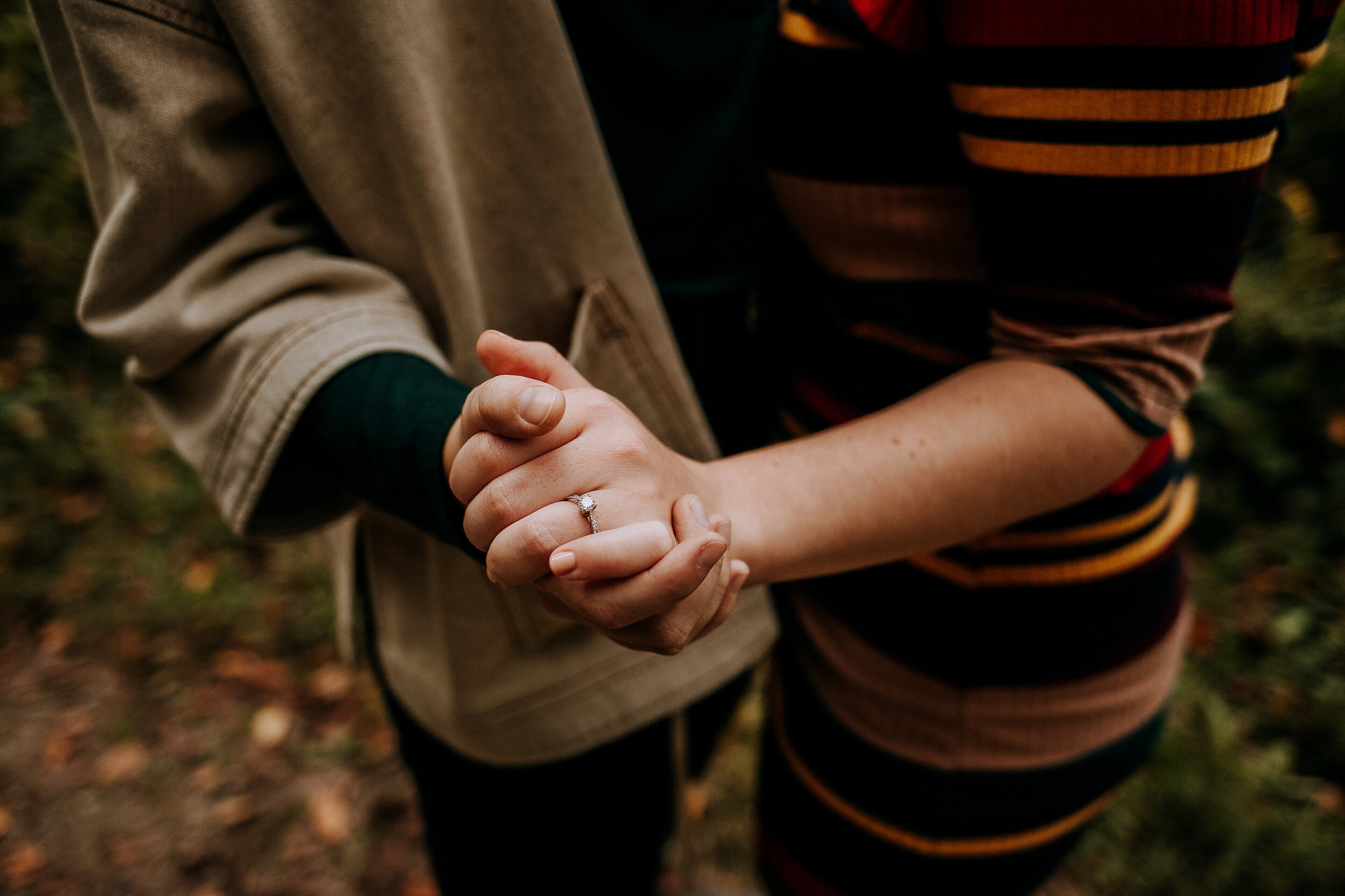  Detail shot of couple holding hands and showing engagement ring in fall outfits in Indiana by Kindred + Co. fall engagement photoshoot fort wayne indiana engagement ring inspo fall outfit photoshoot inspo outdoor wedding photography authentic weddin