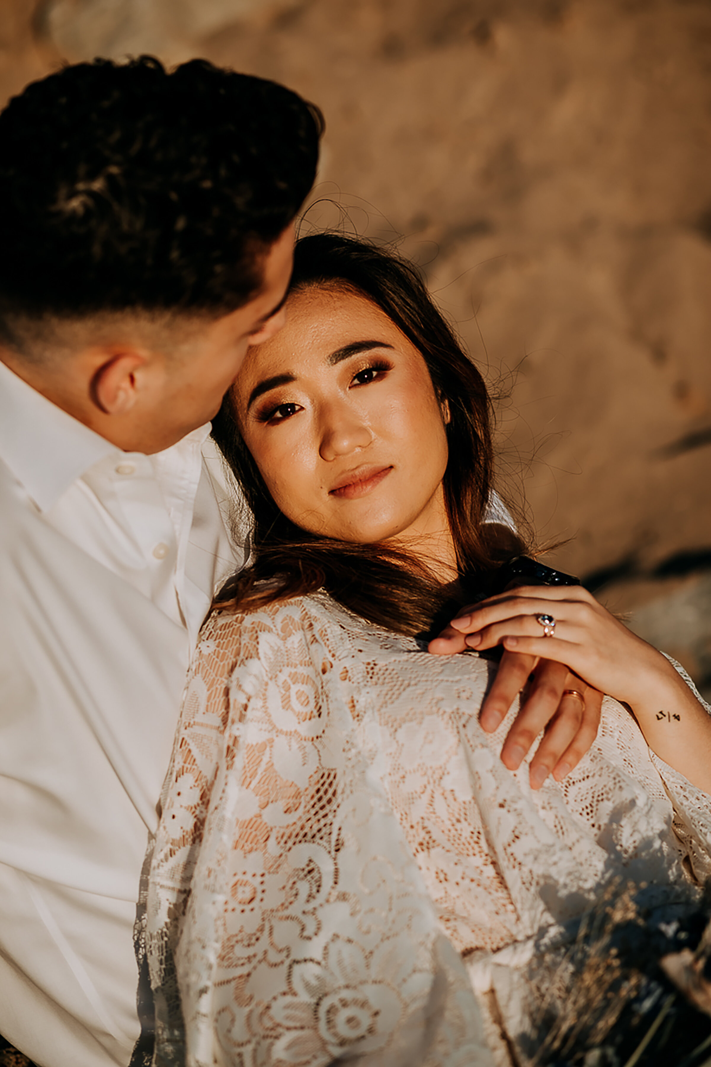  Kindred &amp; Co. Photography captures newly eloped bohemian-styled couple embrace at Indiana Dunes State Park. bohemian elopement, blue diamond engagement ring, groom kissing brides forehead, bell sleeved bohemian elopement dress, professional ogde