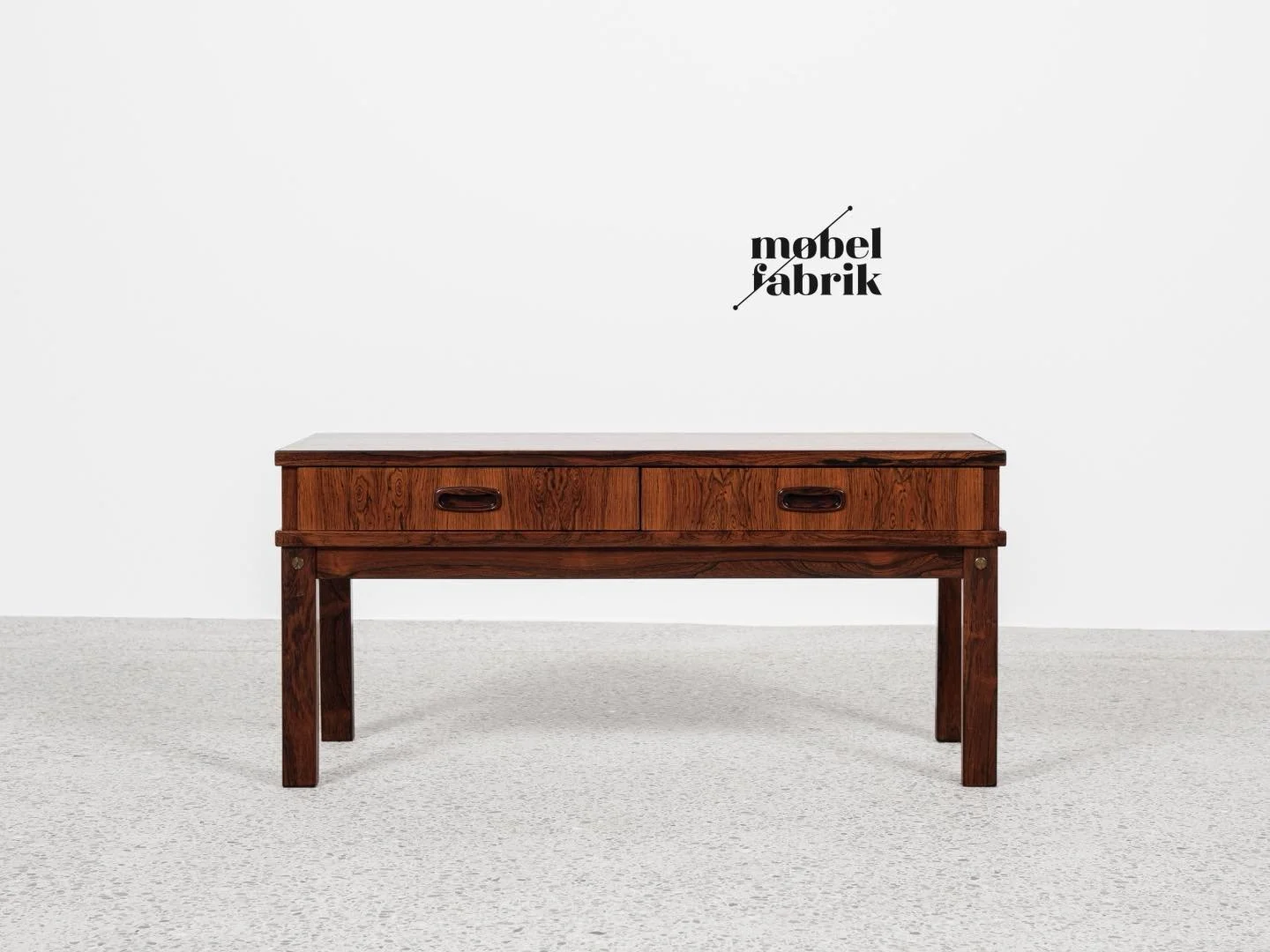 Midcentury Danish chest of 2 drawers in rosewood 1960s

This low chest of 2 drawers is made in Denmark in the 1960s. It could be used as a console table. There are beautiful drawings in the wood, especially on the top. The chest has visible bolts in 