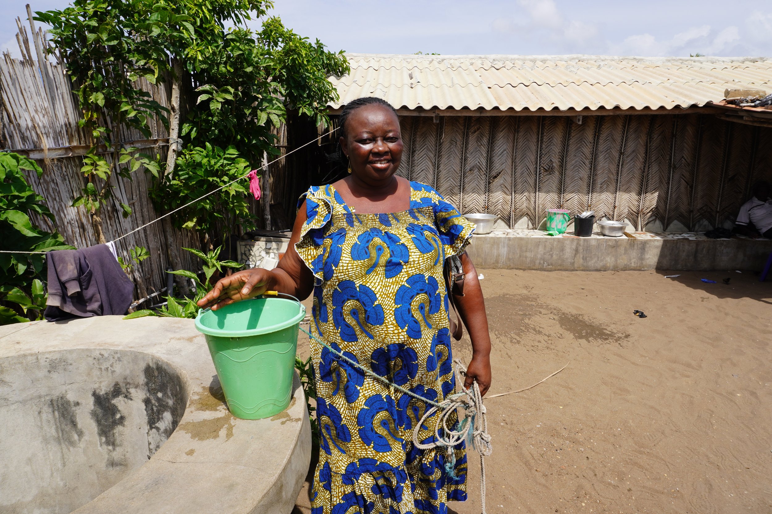  Hortense Sodji pose dans sa cour à côté d’un des seuls puits du village d’Agoué. Sa porte reste toujours ouverte afin que les villageois puissent venir puiser en toute heure. Malgré le fait que nous ne sommes qu’à quelques mètres du rivage, l’eau es
