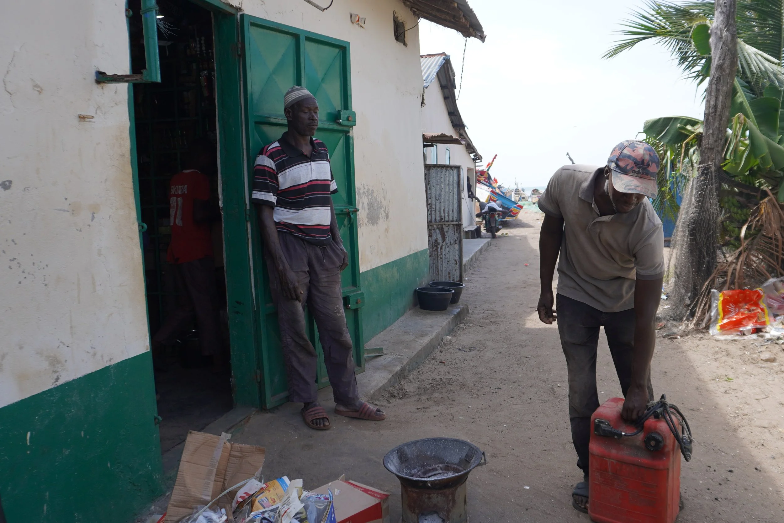  Salif Ndure (à droite) s’apprête à aller chercher de l’essence pour une prochaine sortie en mer. Désormais, les sorties de pêche sont plus longues et les pêcheurs doivent aller plus loin à cause de la raréfaction du poisson en zone côtière. Les dépe