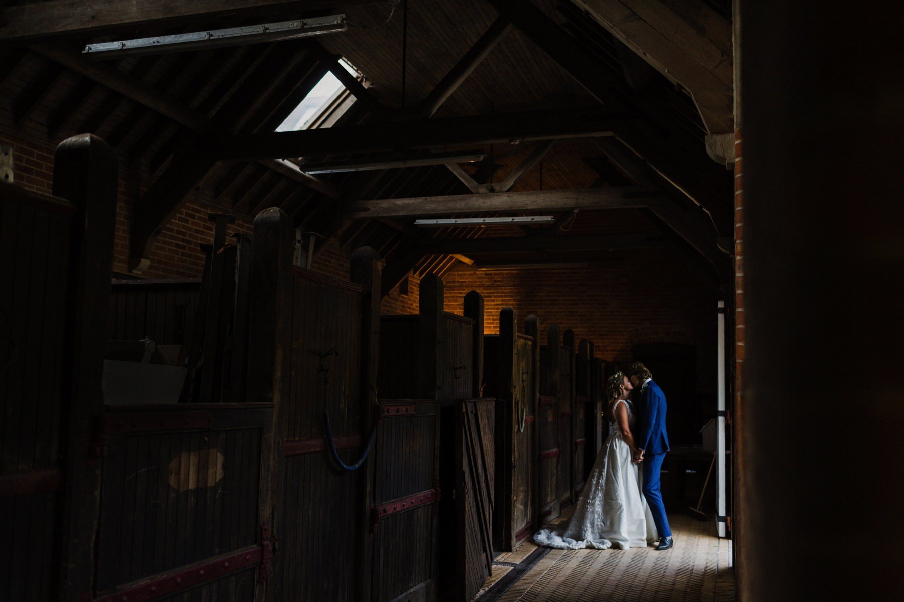 A couple kiss for their wedding portraits at Kingsettle Stud wedding venue