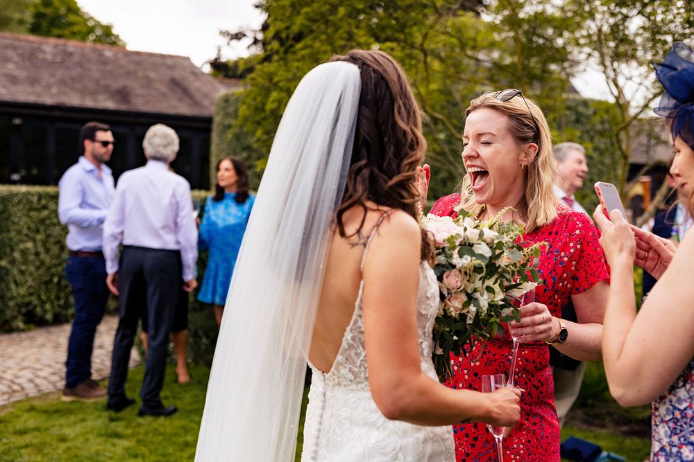 A wedding guest scream with excitement as she sees her friend getting married.