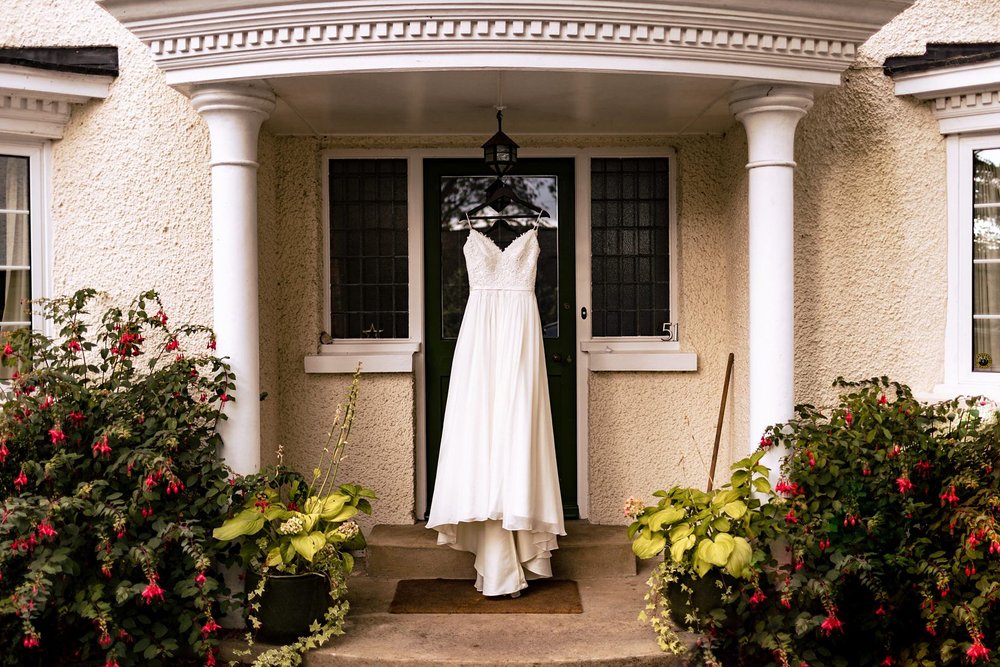 A wedding dress hung up in a porch over a front door