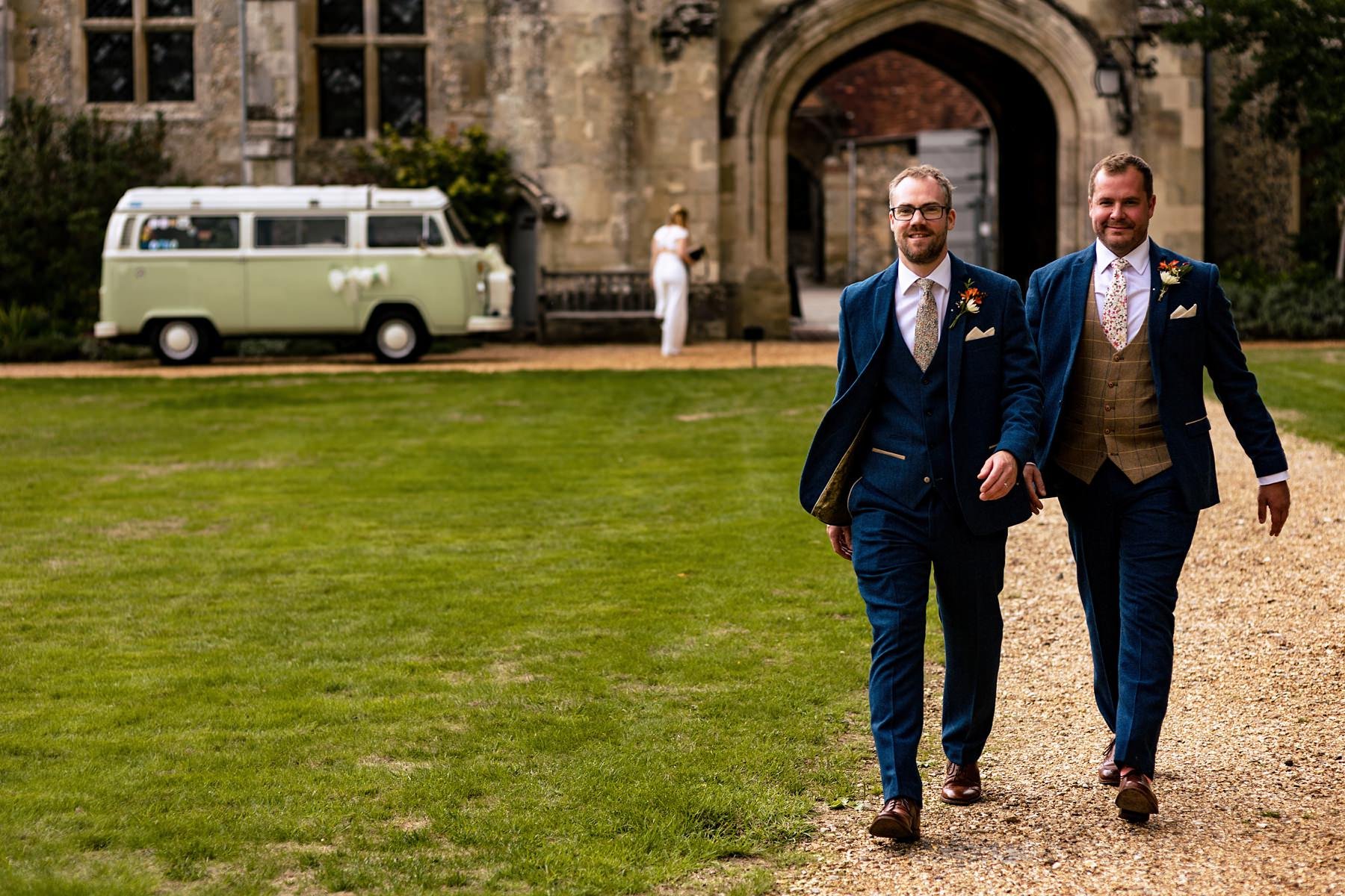 A groom and his best man walk to the church at St Cross in Winchester
