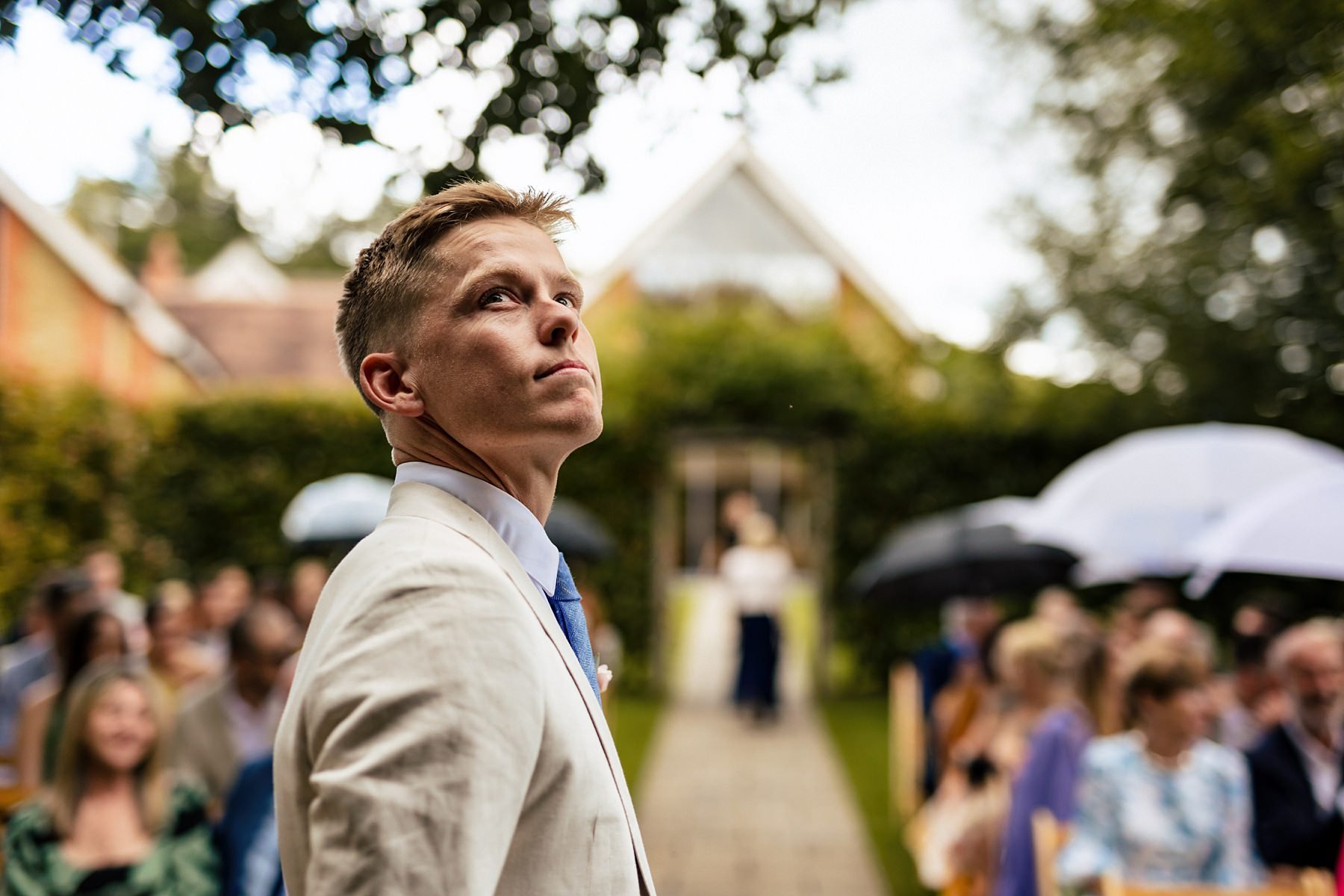 A groom observes the rain as he prepares for his wedding ceremony at Millbridge Court