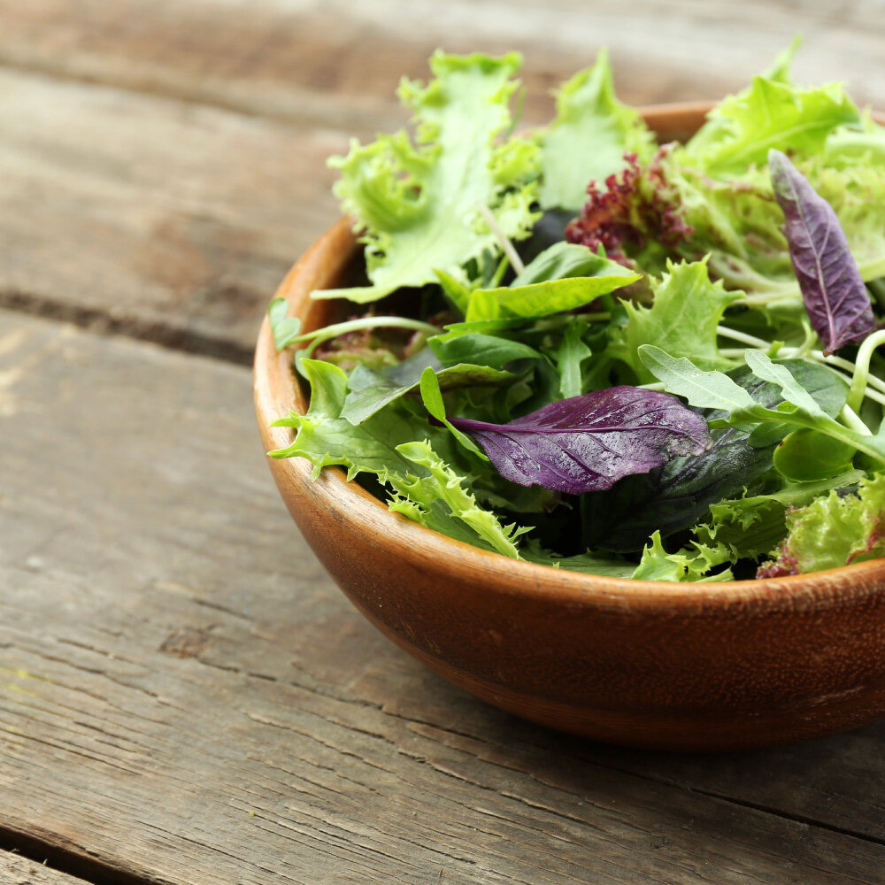  Image of fresh greens salad in a wooden bowl 