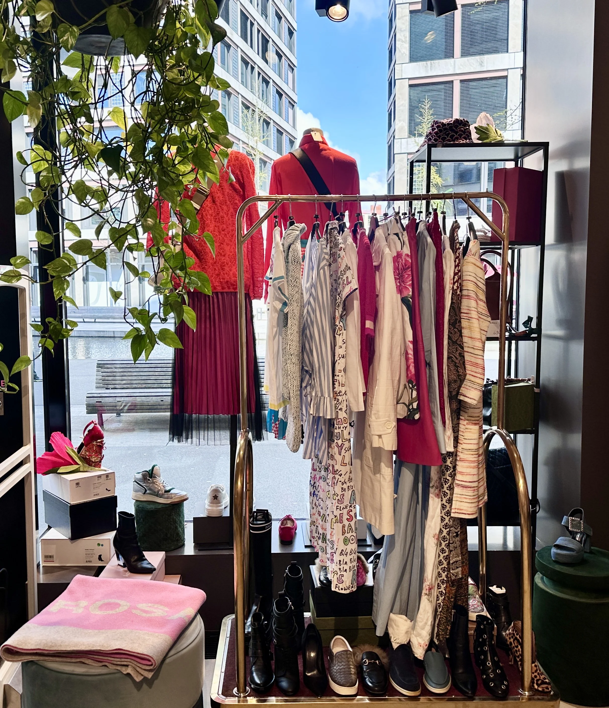 Modenschau mit bunten Kleidern und Schuhen in einem Schaufenster