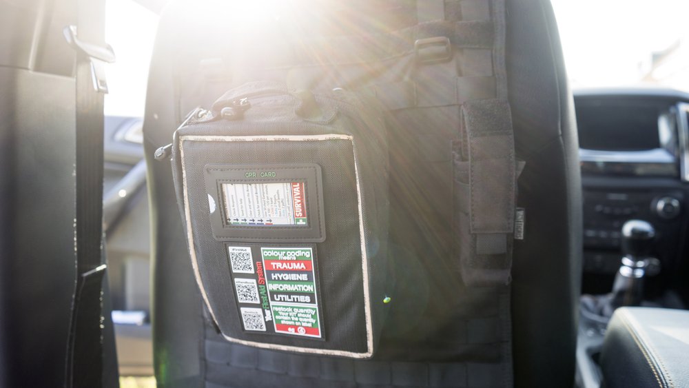  SURVIVAL first aid kit attached to a vehicle seat back organiser using the provided MOLLE strapping 