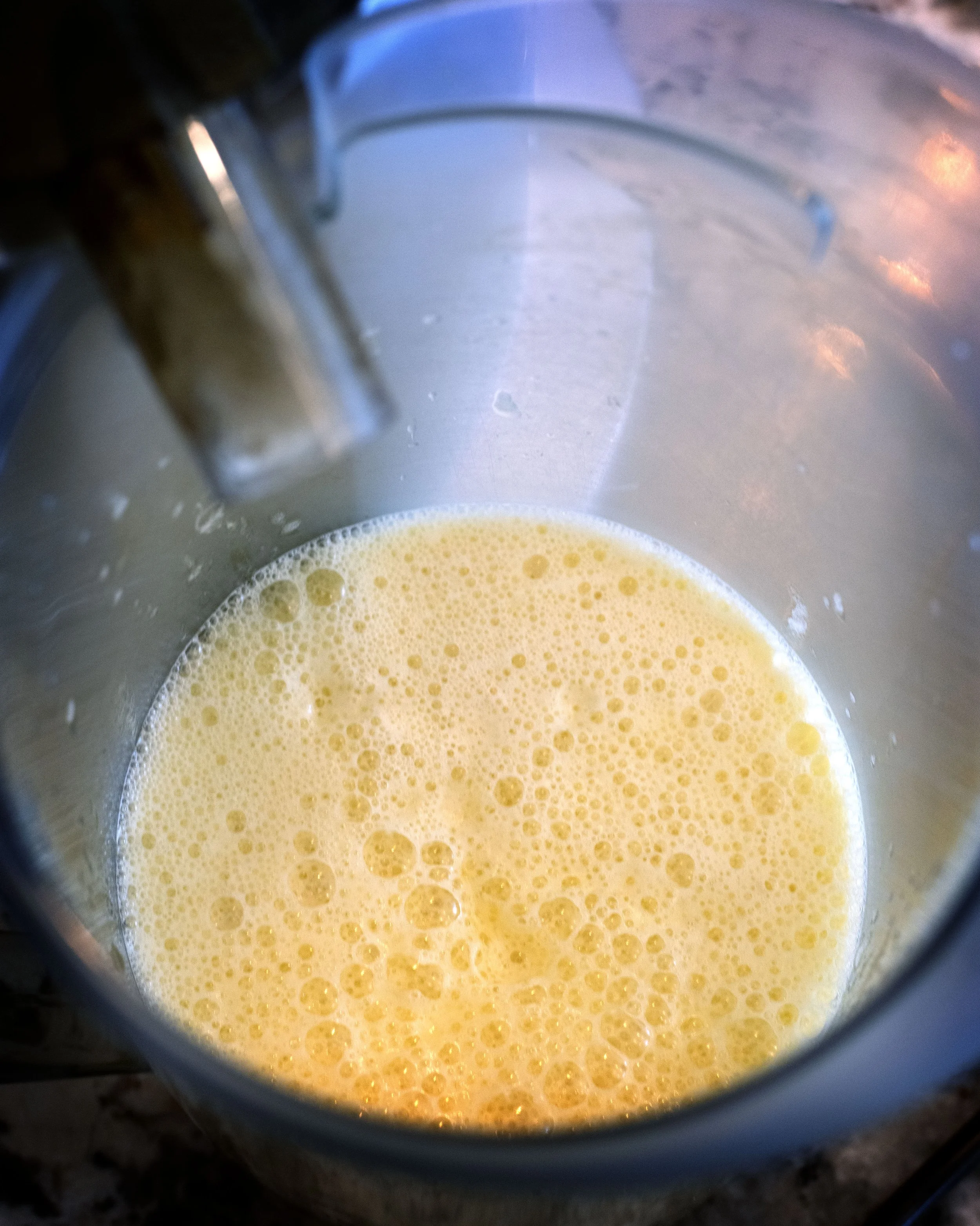 Fresh pineapple juice in a jar next to a breville juicer