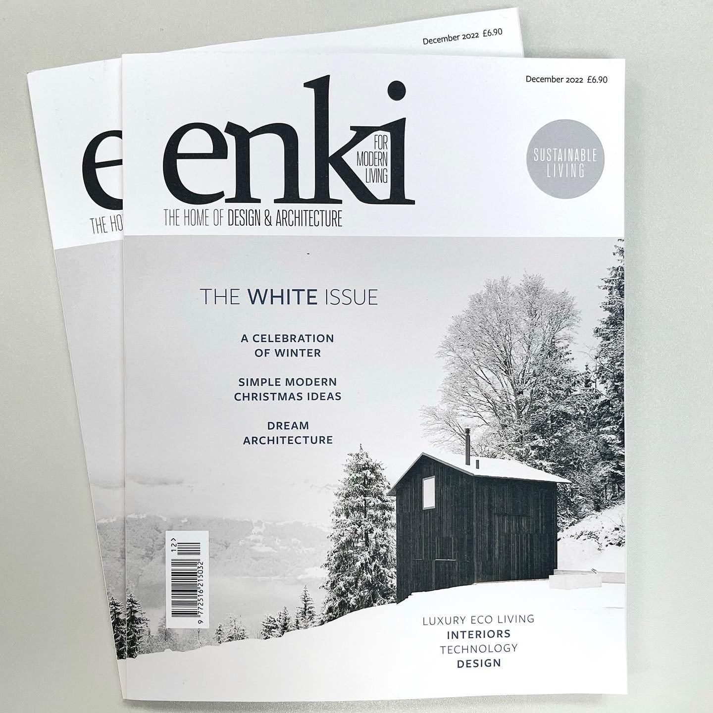 Two copies of inky magazine sit on a white table. The magazine cover reads' 'the white issue; a celebration of winter, simple modern Christmas ideas, and Dream architecture'. Enki is a design and architecture magazine for sustainable living.