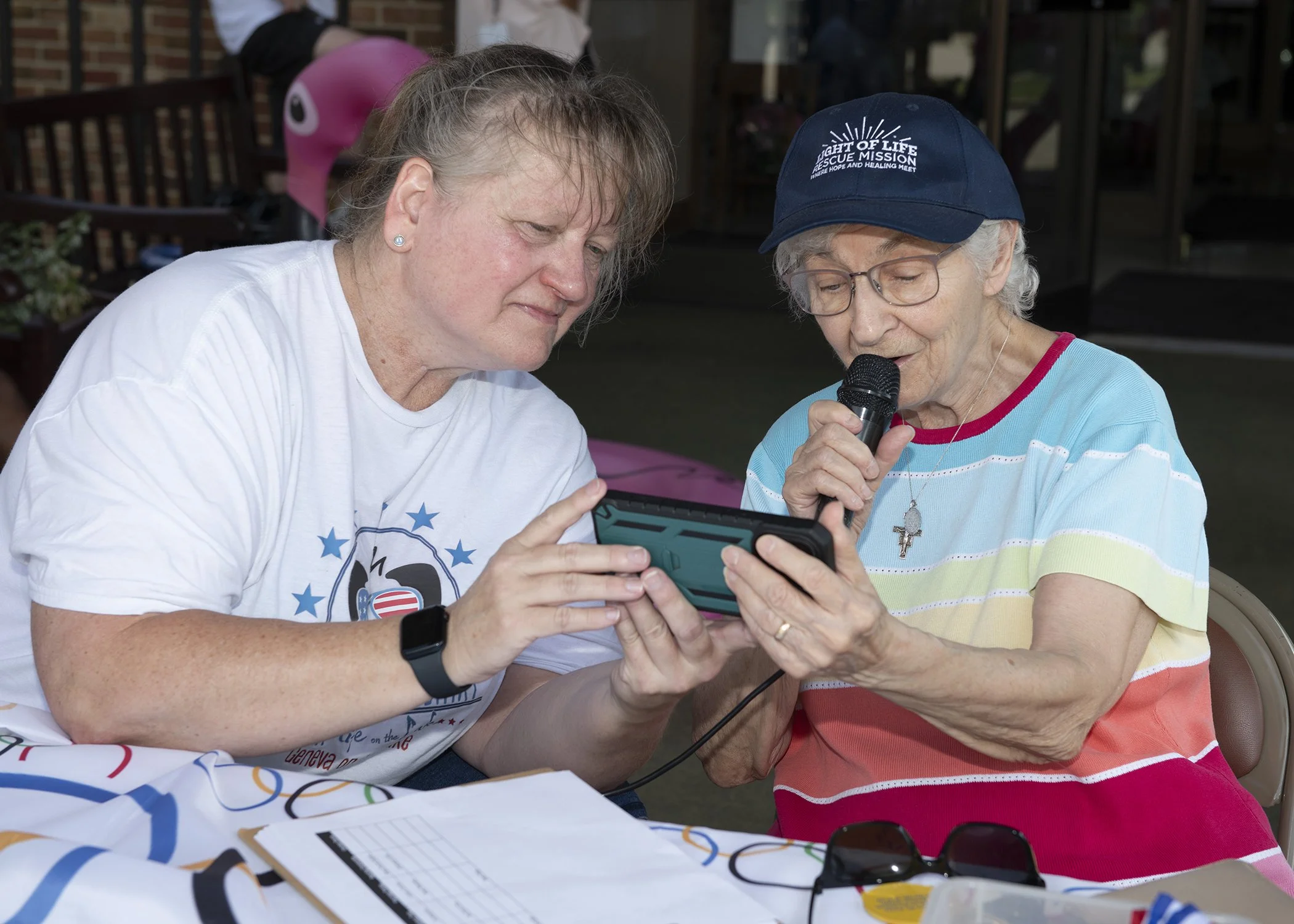 Event emcee Nicole Buchlmayer assists as Sister Georgette Dublino reads our opening prayer.