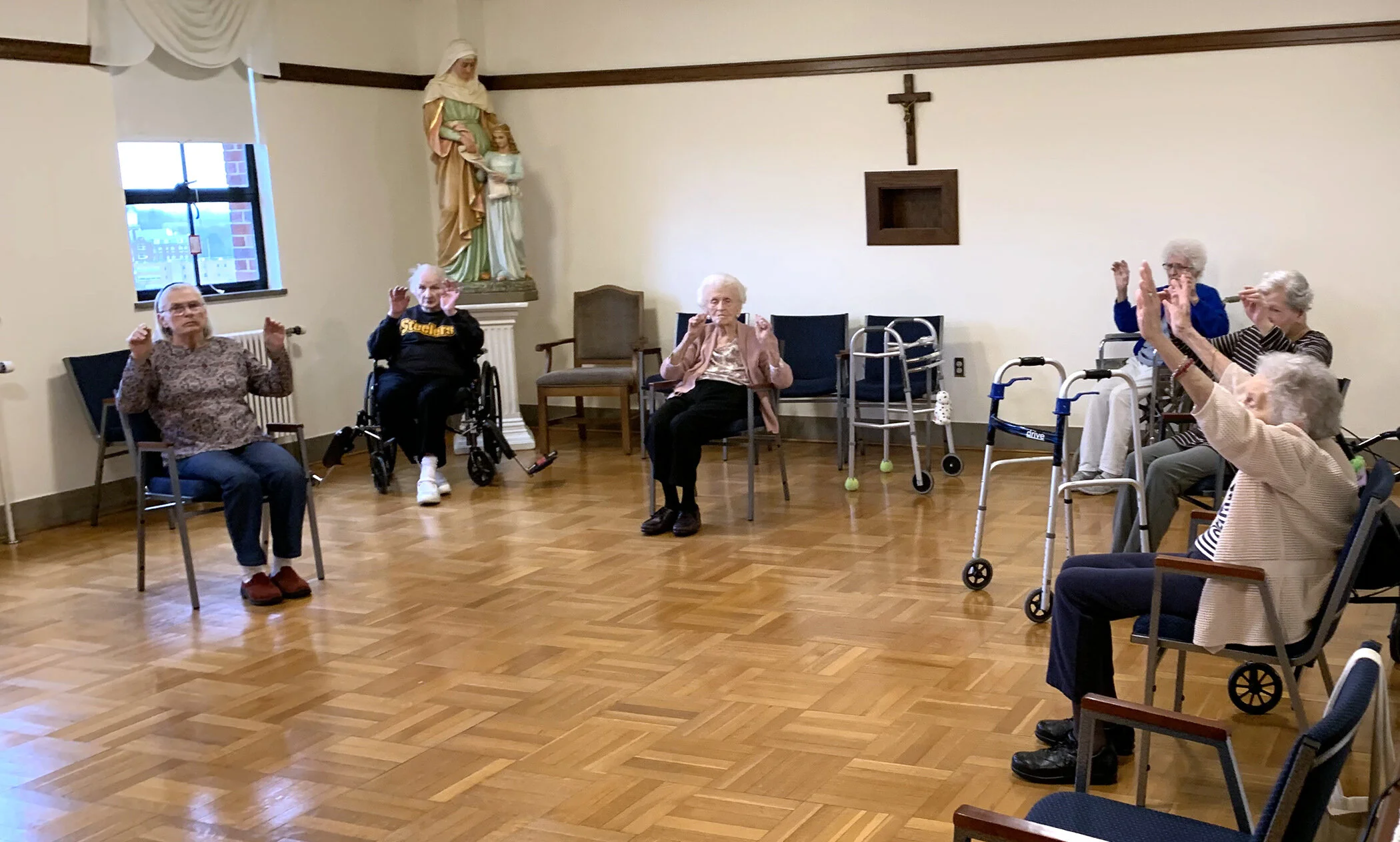 Residents of Antonia Hall practice social distancing while taking part in seated exercise.