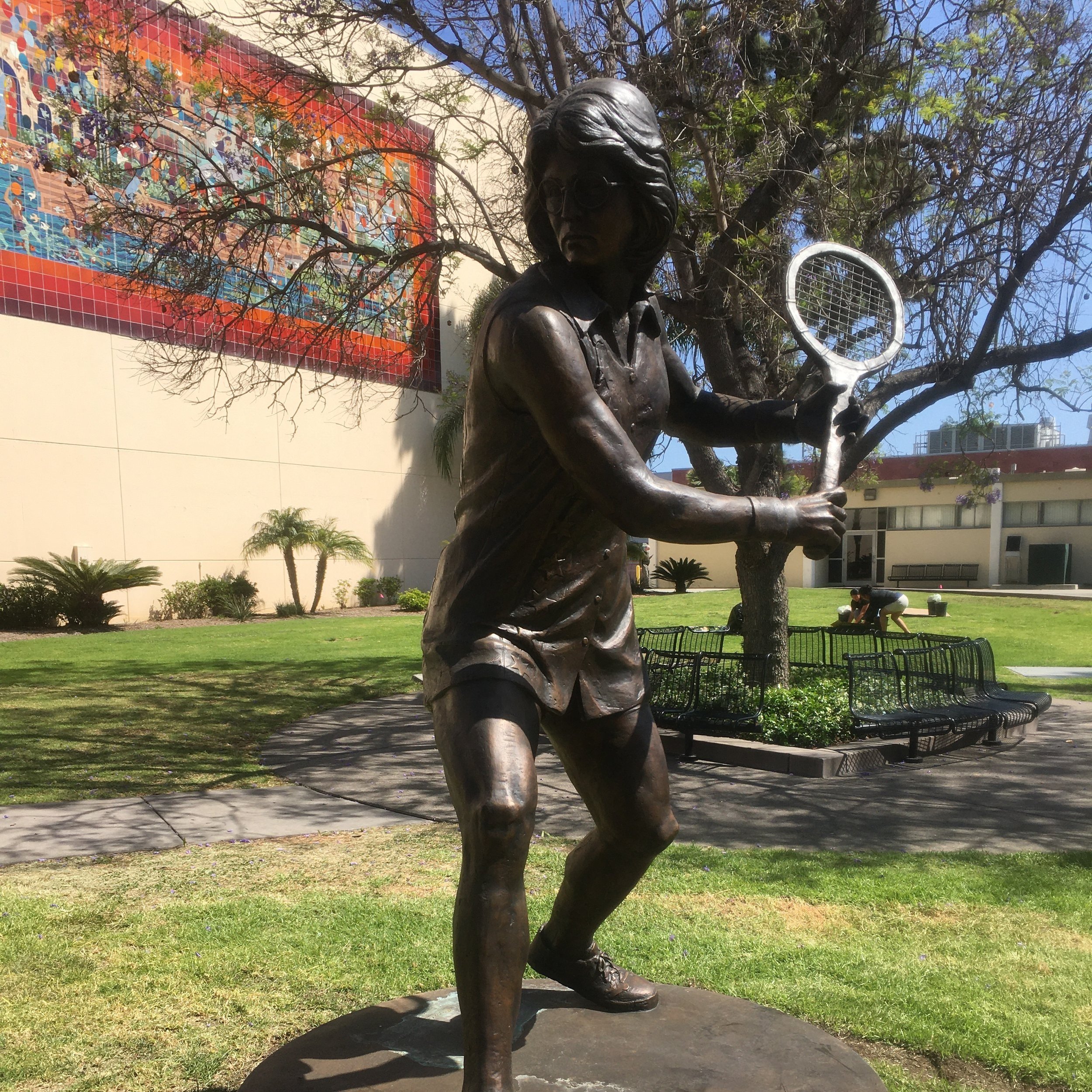 Statue of Billie Jean King in front of "Olympic Fantasy" mural