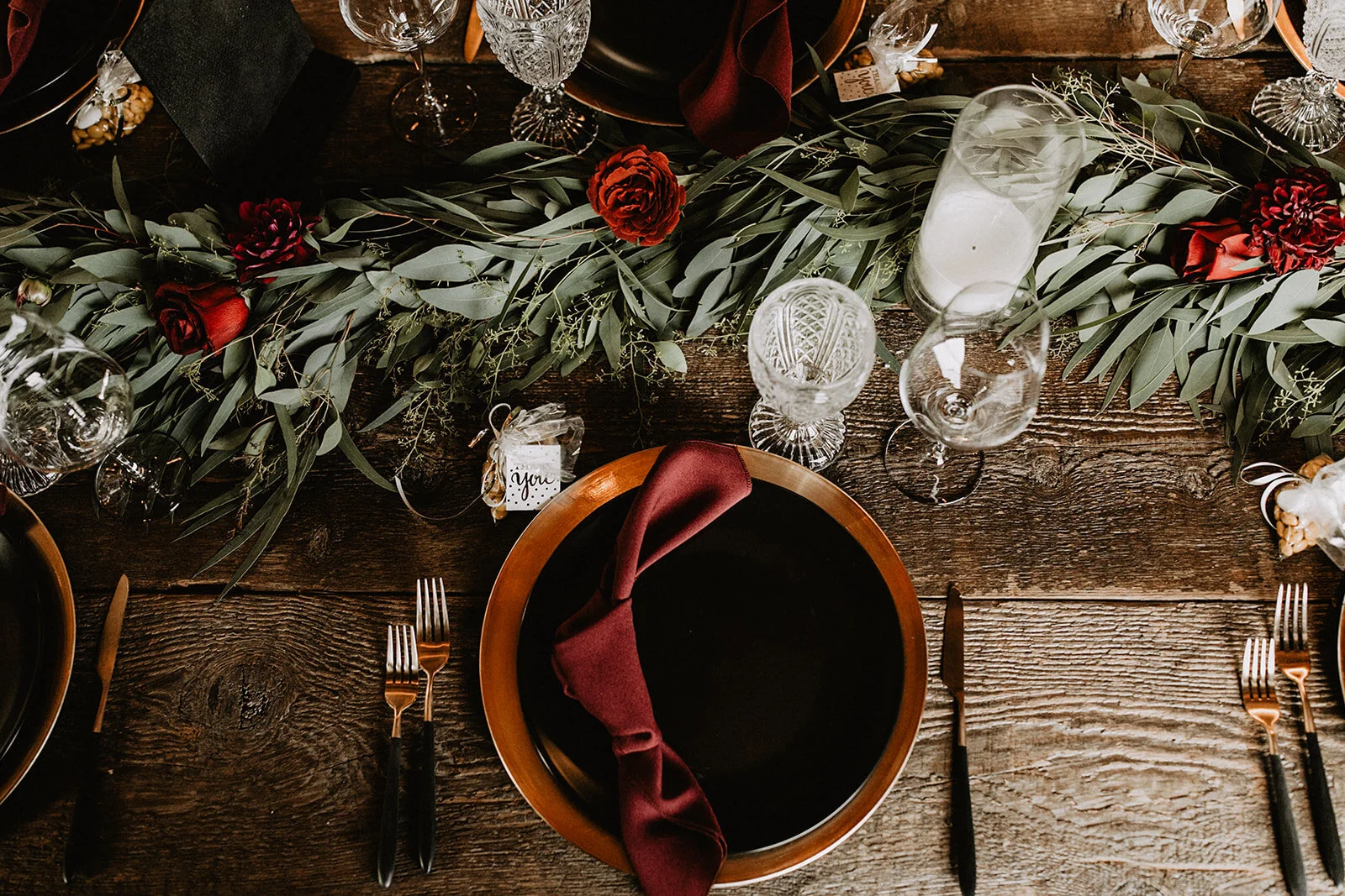 Red floral tablescape with garland and napkin treatment