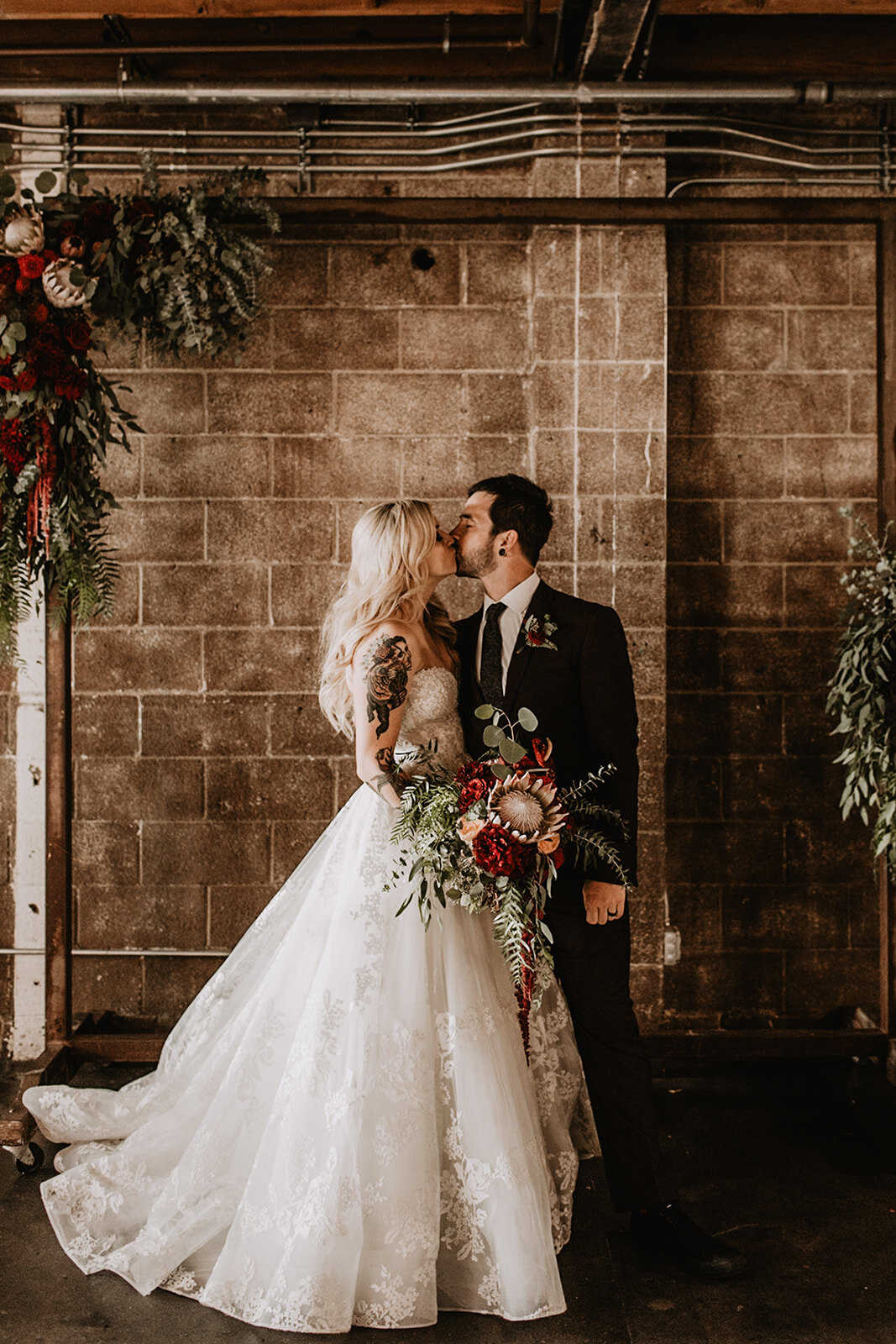 Warehouse wedding ceremony and arch with moody flowers and bouquet