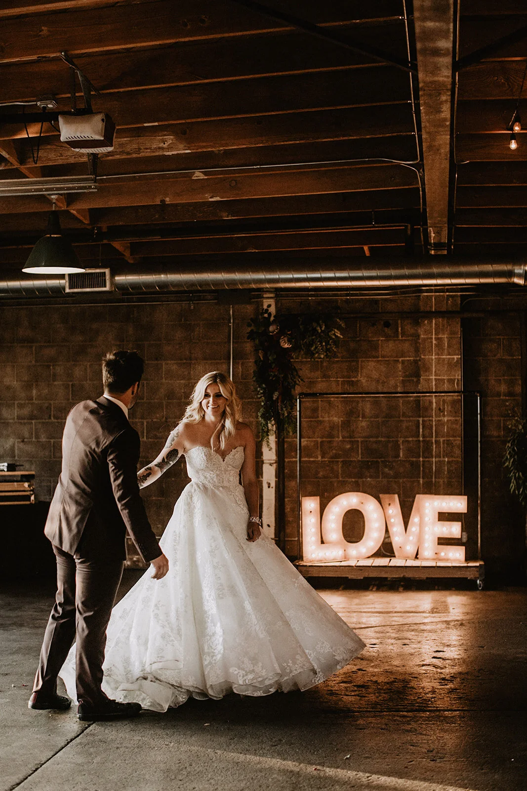 LOVE signage at Smoky Hollow Studios with bride and groom