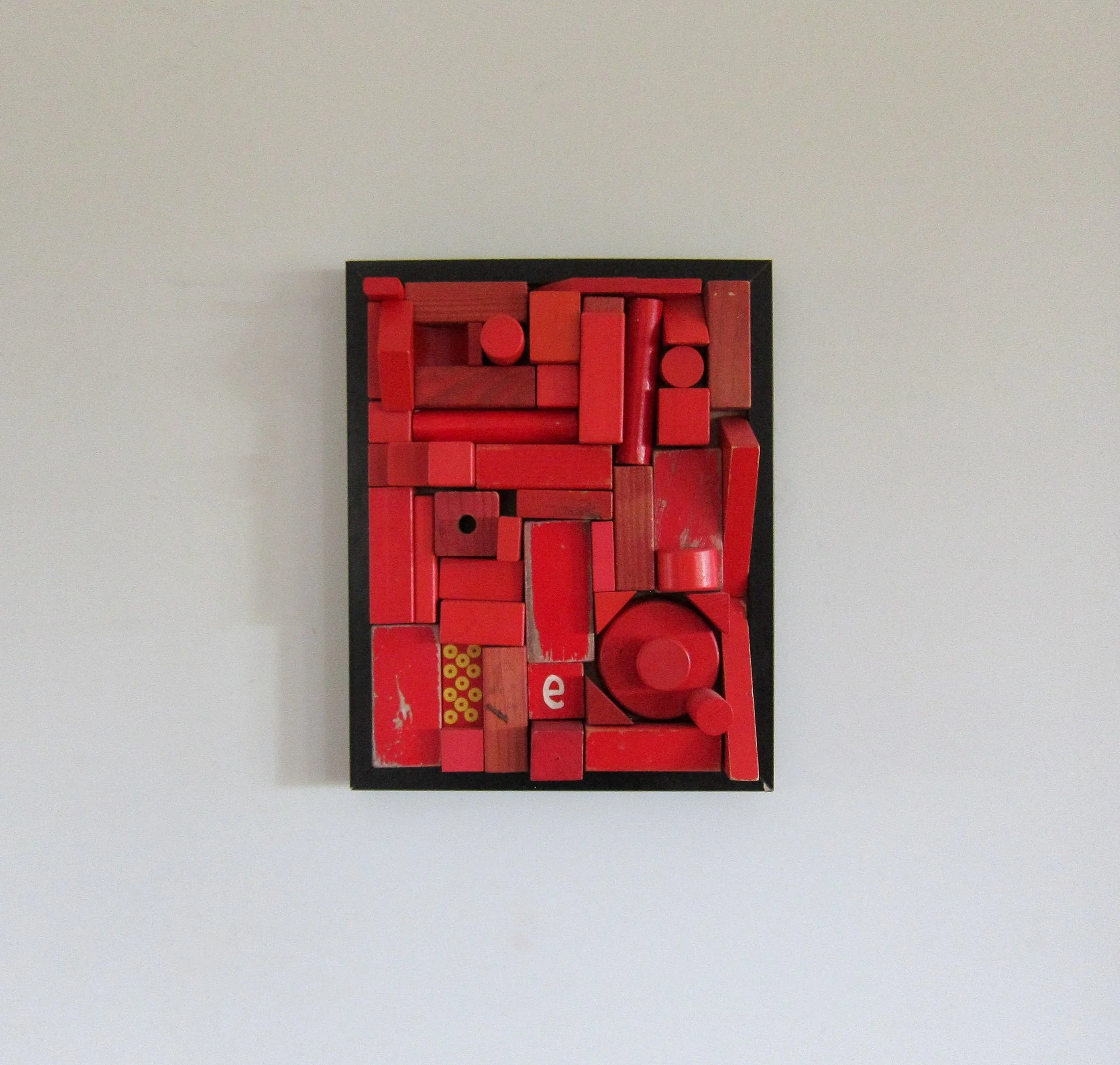 Abstract red geometric shapes arranged in a grid-like pattern against a white background.