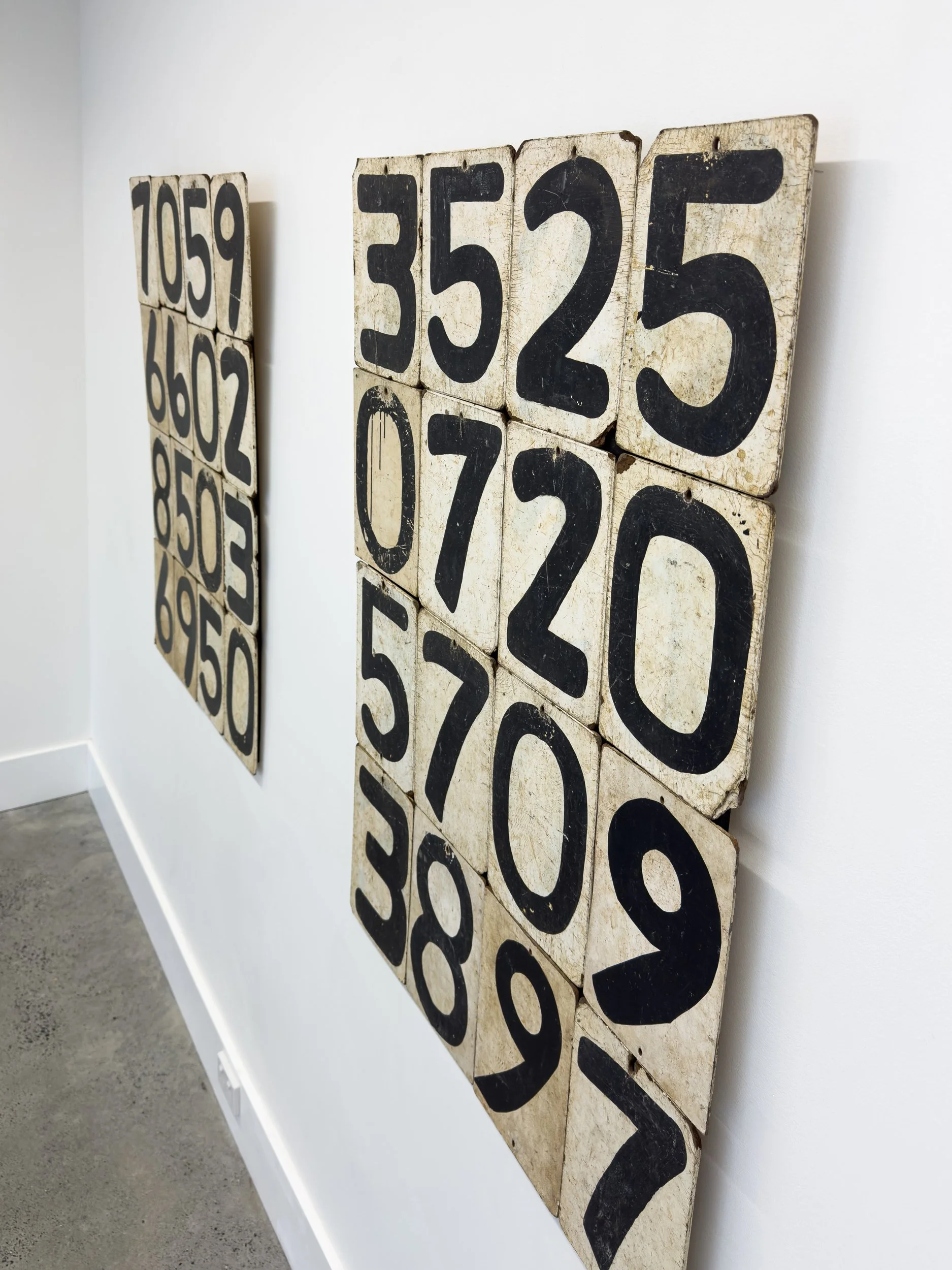 Wall art features vintage, block-style numbers on aged, distressed tiles arranged prominently. The scene has an industrial, nostalgic feel.