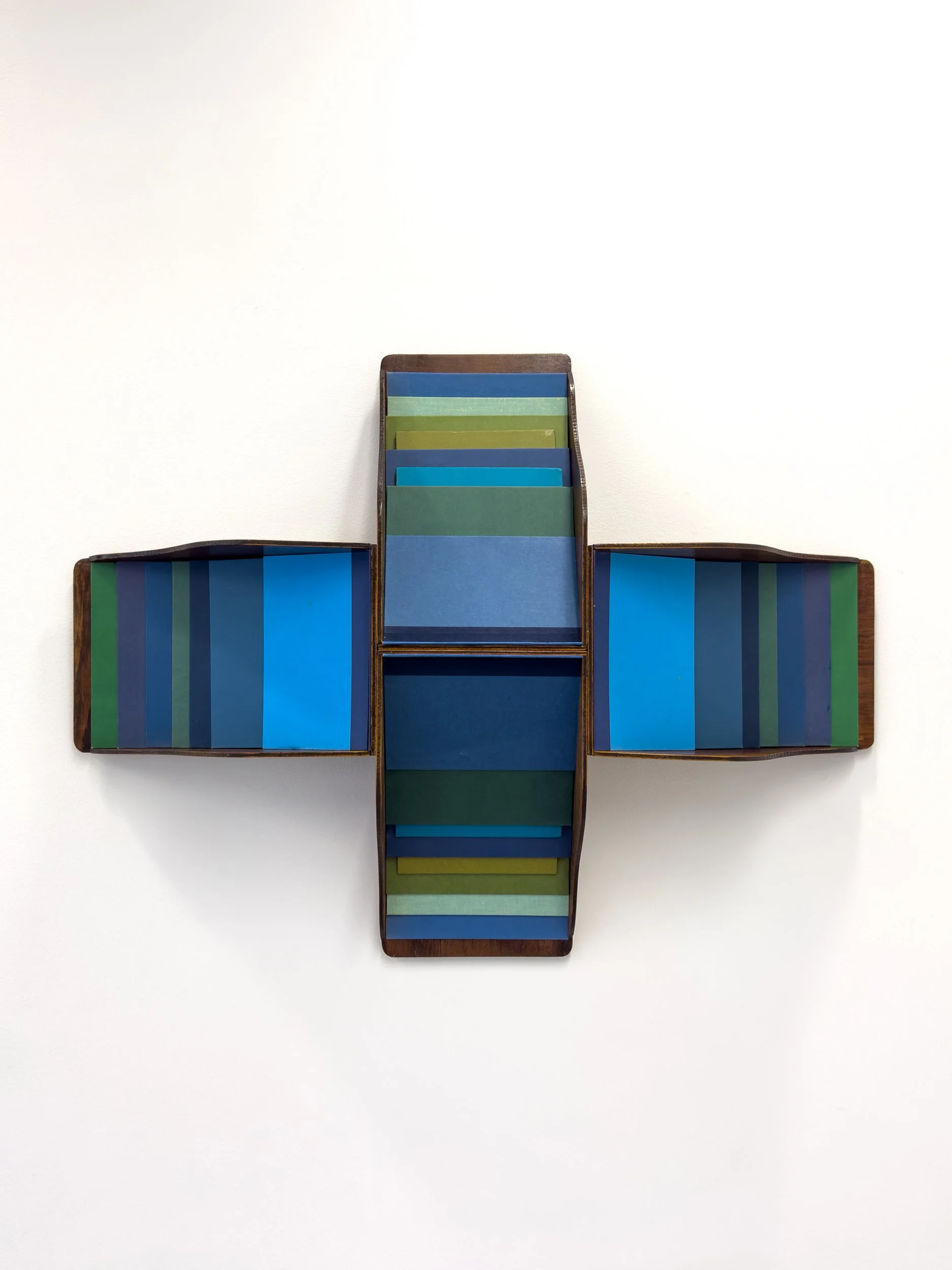 Abstract artwork featuring a cross-shaped structure with colorful horizontal stripes. Shades of blue, green, and yellow create a calming, geometric pattern.