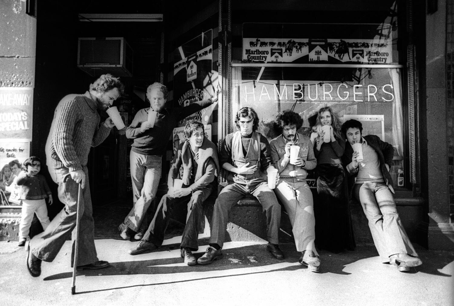 All Australian Graffiti studio (1975-1978), from left: Geoff Cook, Izi Marmur, Tony Ward, Neil Curtis, Mimmo Cozzolino, Meg Williams, Con Aslanis in St Kilda Road, St Kilda, two doors from our studio. Photography by Bob Bourne, 1977