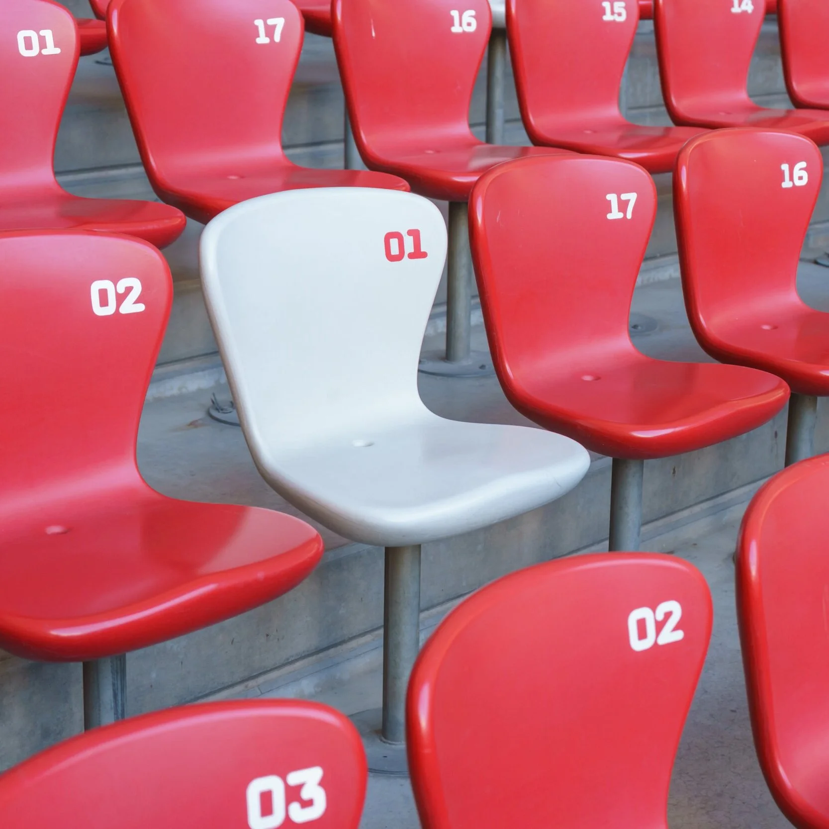 A white chair in a sea of red ones