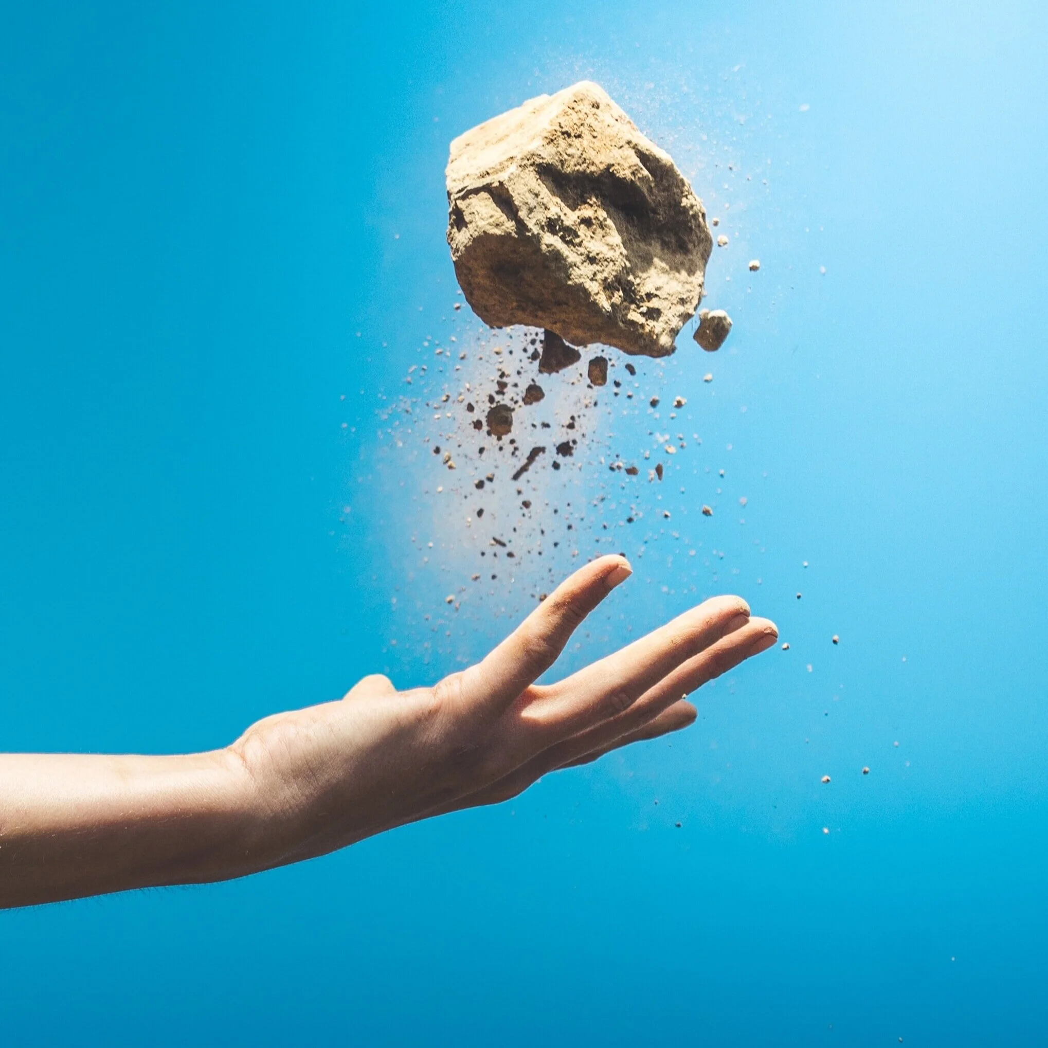 A hand tossing a rock