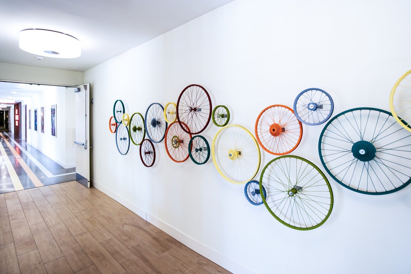 Inspired by the rhythm of bicycle wheels and the spirit of shared journeys, this custom fabricated art piece brings playful energy to a vibrant Columbus community. Circular forms and bold color stories with Sherwin Williams specifications echo themes