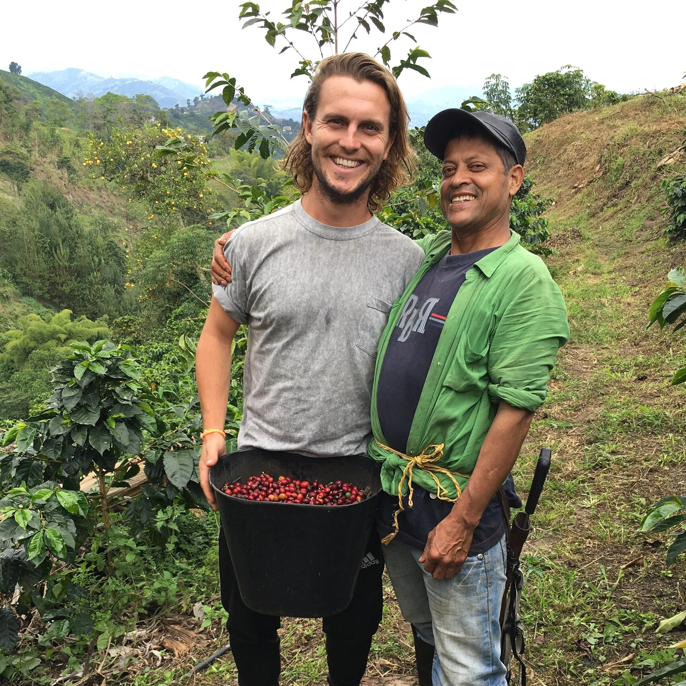 Manuel and I at the top of the plantation after a morning coffee picking. He let me borrow his full bucket for the photo.
