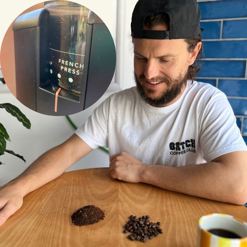 Tom with ground coffee and a coffee grinder.