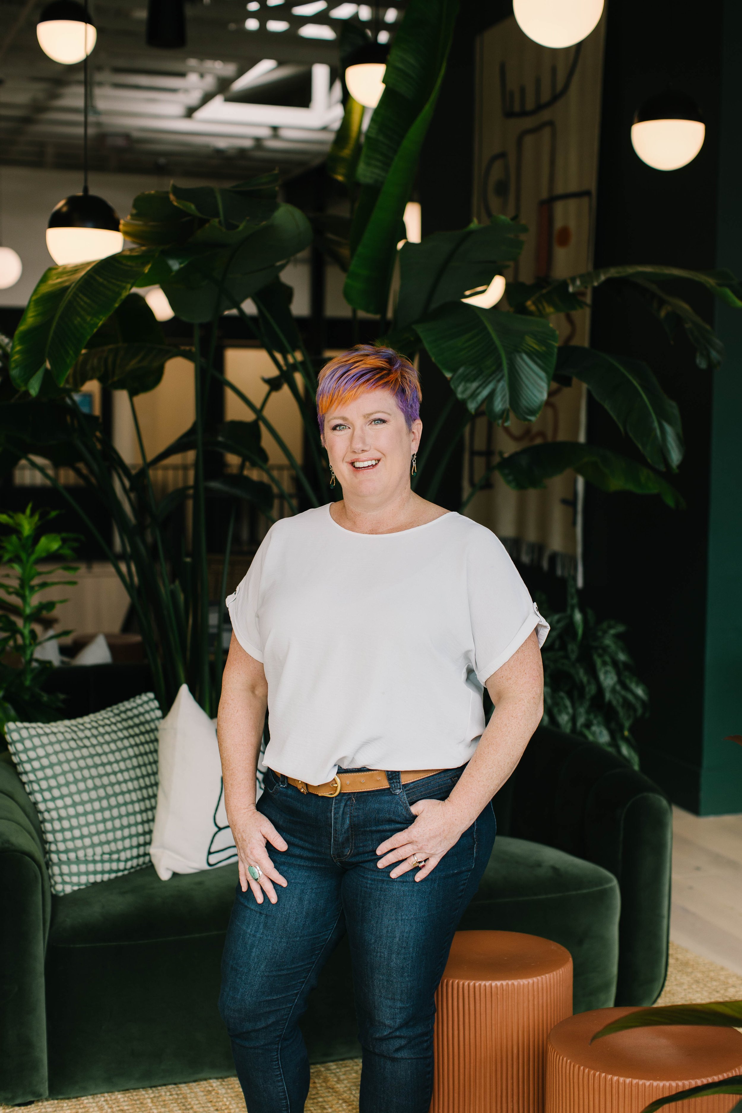 Cassidy DuHadway, Purple Sky Counseling founder and author of Becoming Me, smiles by a green velvet couch. Her book speaks to readers carrying religious or generational trauma. Becoming Me is available now on Amazon.