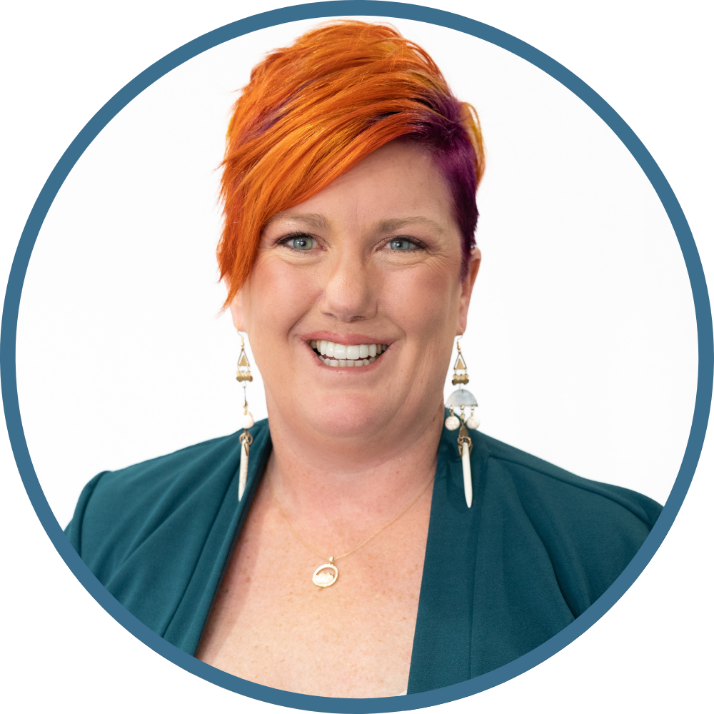 A smiling EMDR therapist in a teal blazer who knows how hard it can be to talk about trauma. EMDR therapy in Utah helps the brain process painful memories so they lose their charge. Learn about EMDR at Purple Sky Counseling.