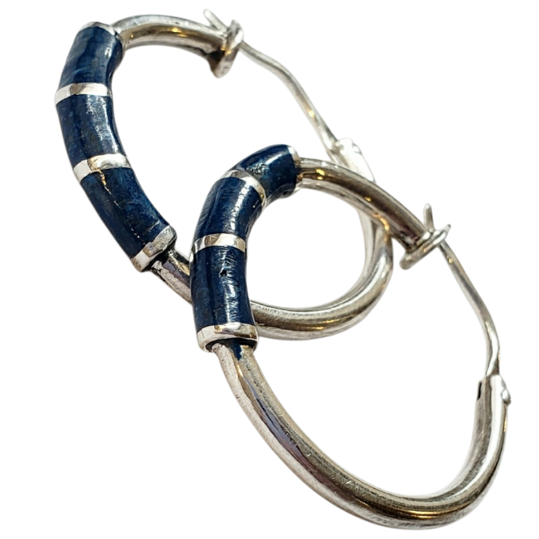 Handcrafted silver hoops featuring lapis inlay segments that create a subtle rhythm of color and texture. A refined piece with a deep blue presence and a contemporary artisanal finish.