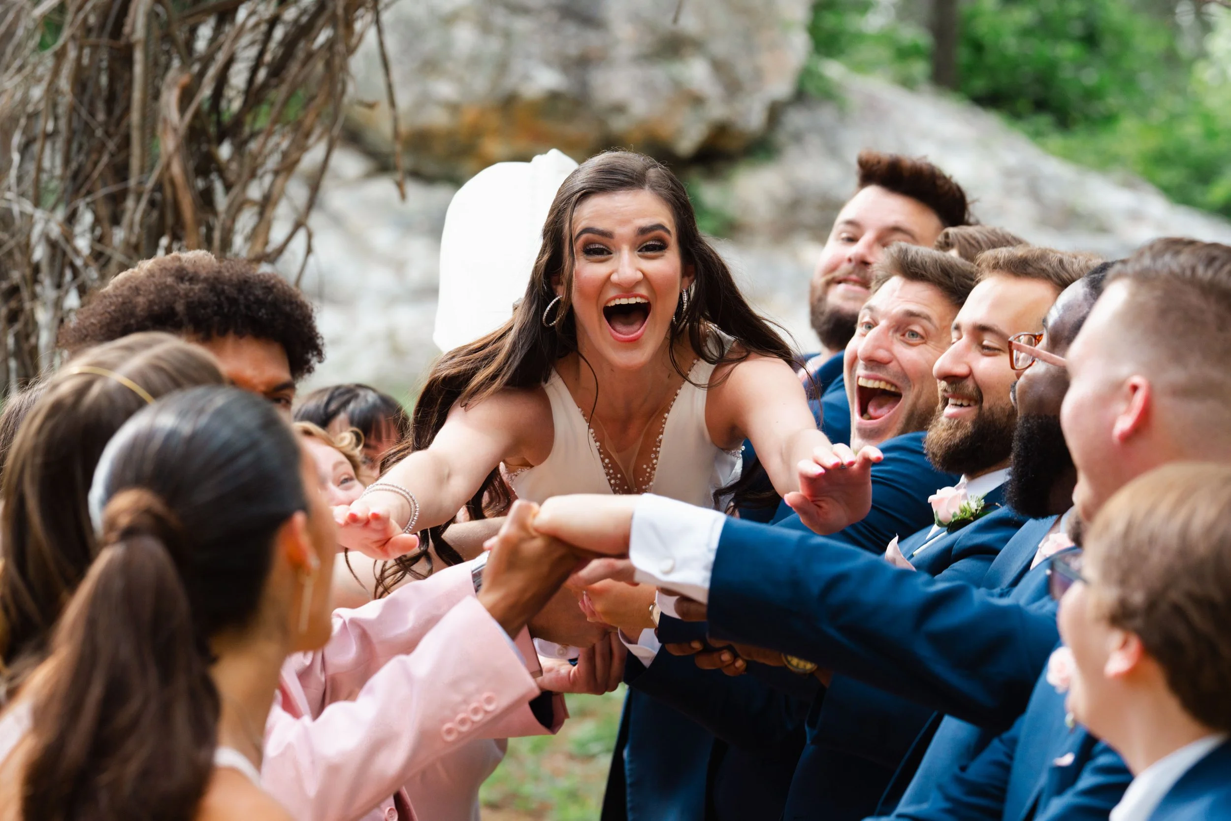 Bride being tossed in air by bridesmaids and groomsmen, fun wedding party sendoff