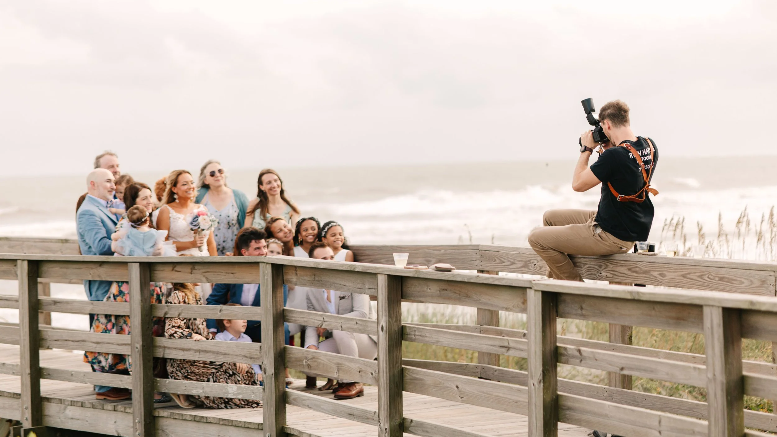 Destination beach wedding in North Carolina, wedding photography on beach pier, family beach photos, overcast wedding photography, group family photo