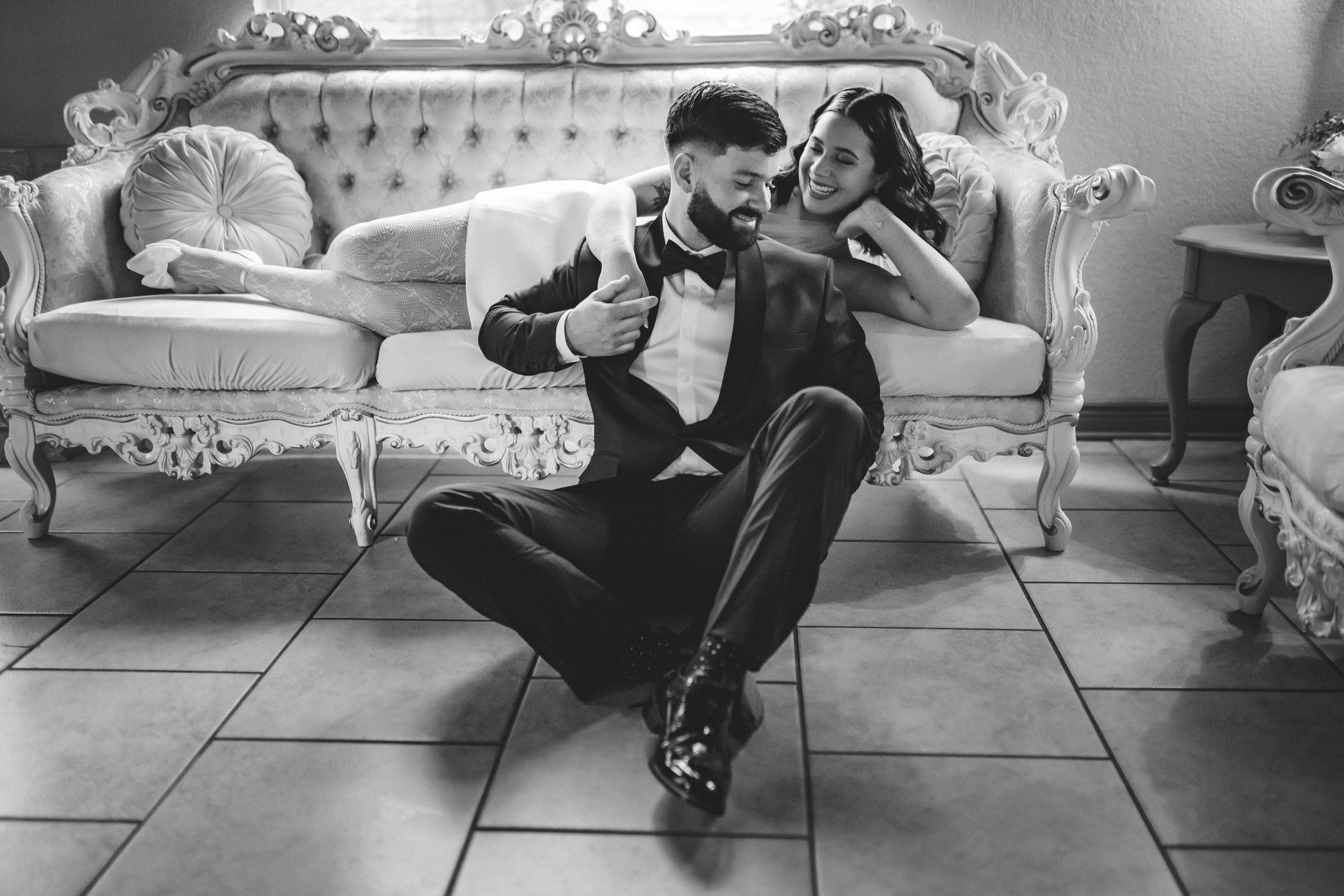 Intimate moments of Bride and Groom in a romantic pose on a vintage sofa in bridal suite on wedding day