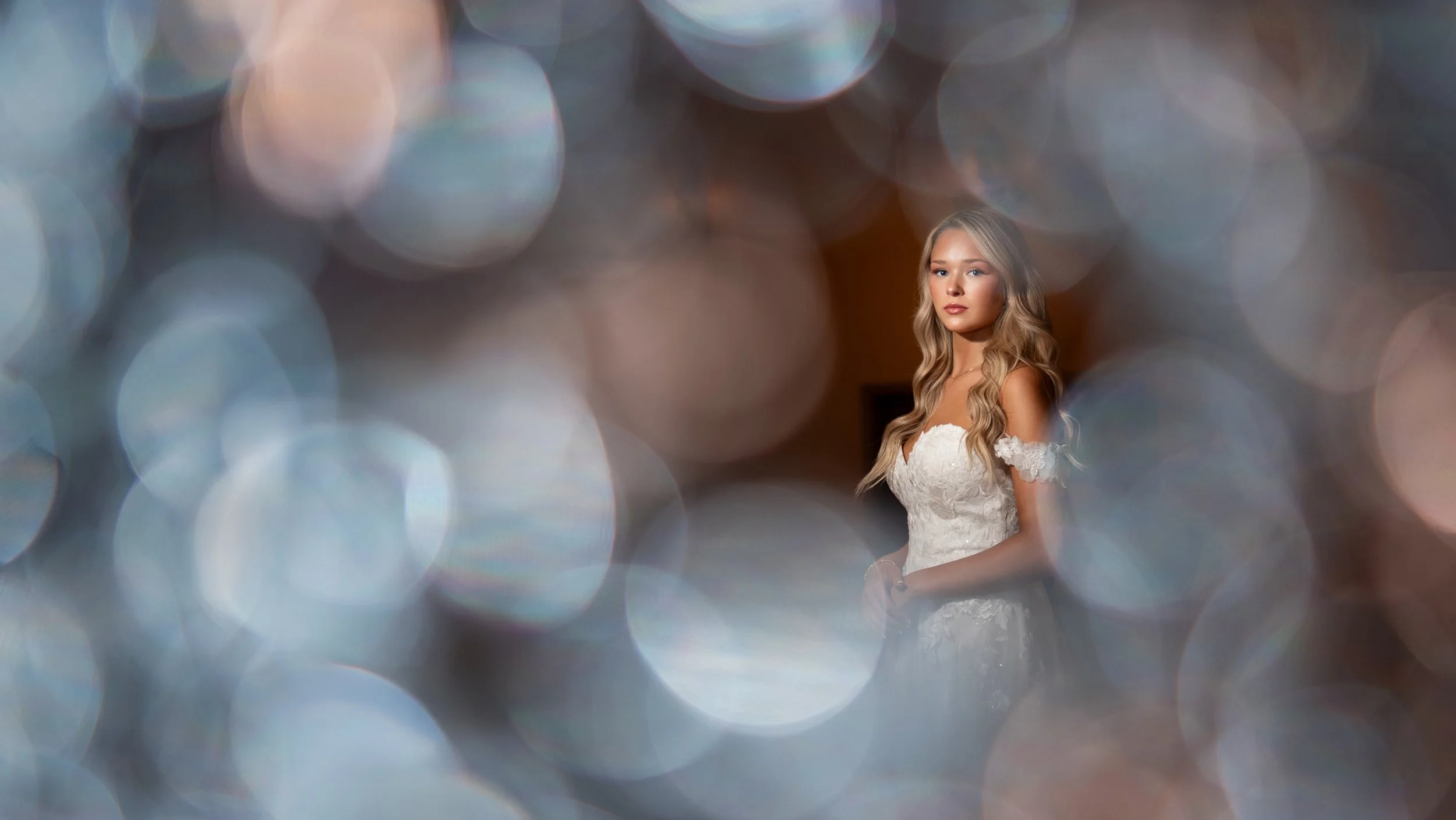 Indoor bridal photoshoot with a blurred background of colorful bokeh lights, sparkle light effect photography