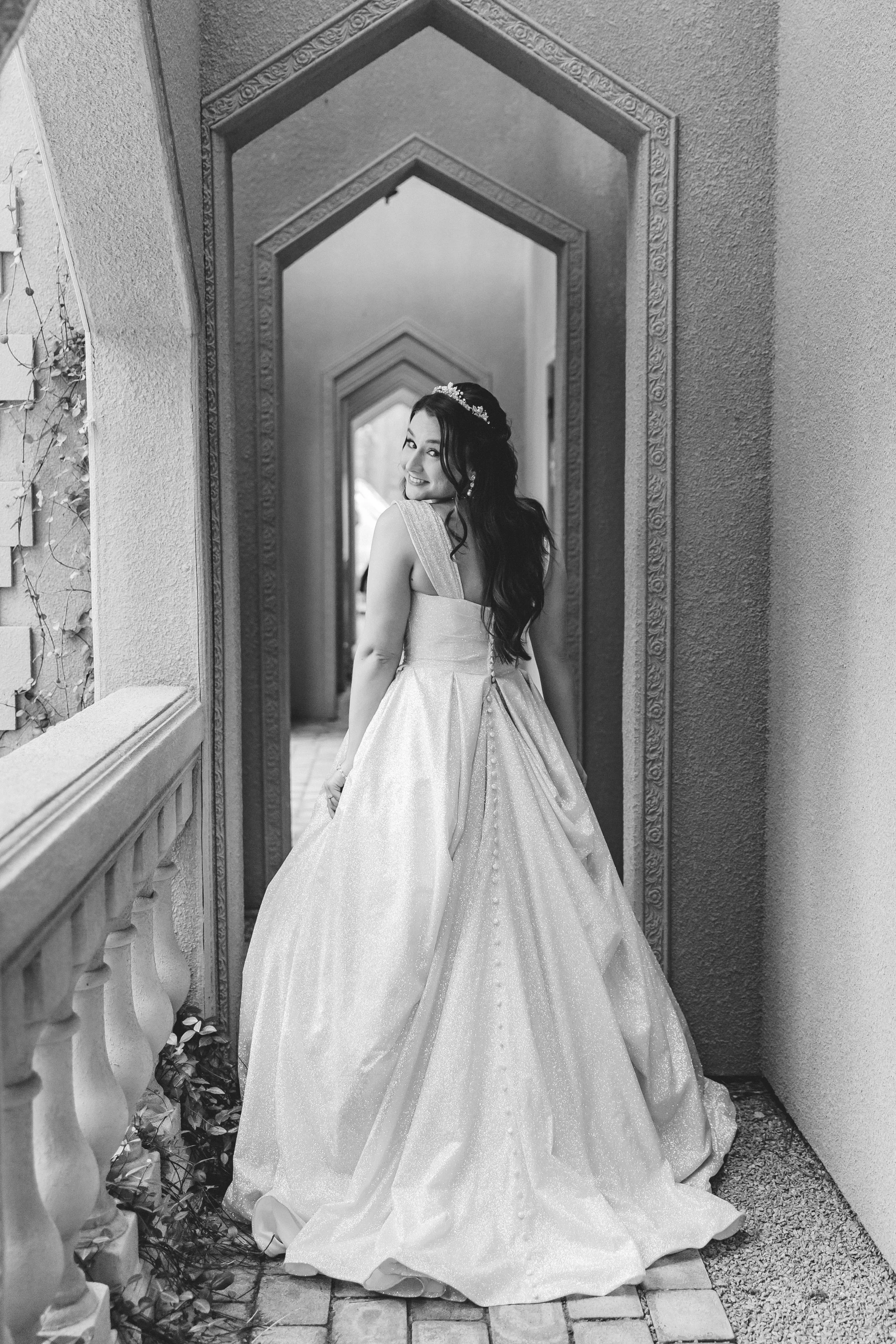 Fairytale wedding castle venue, bride smiling and looking back over her shoulder in a hallway