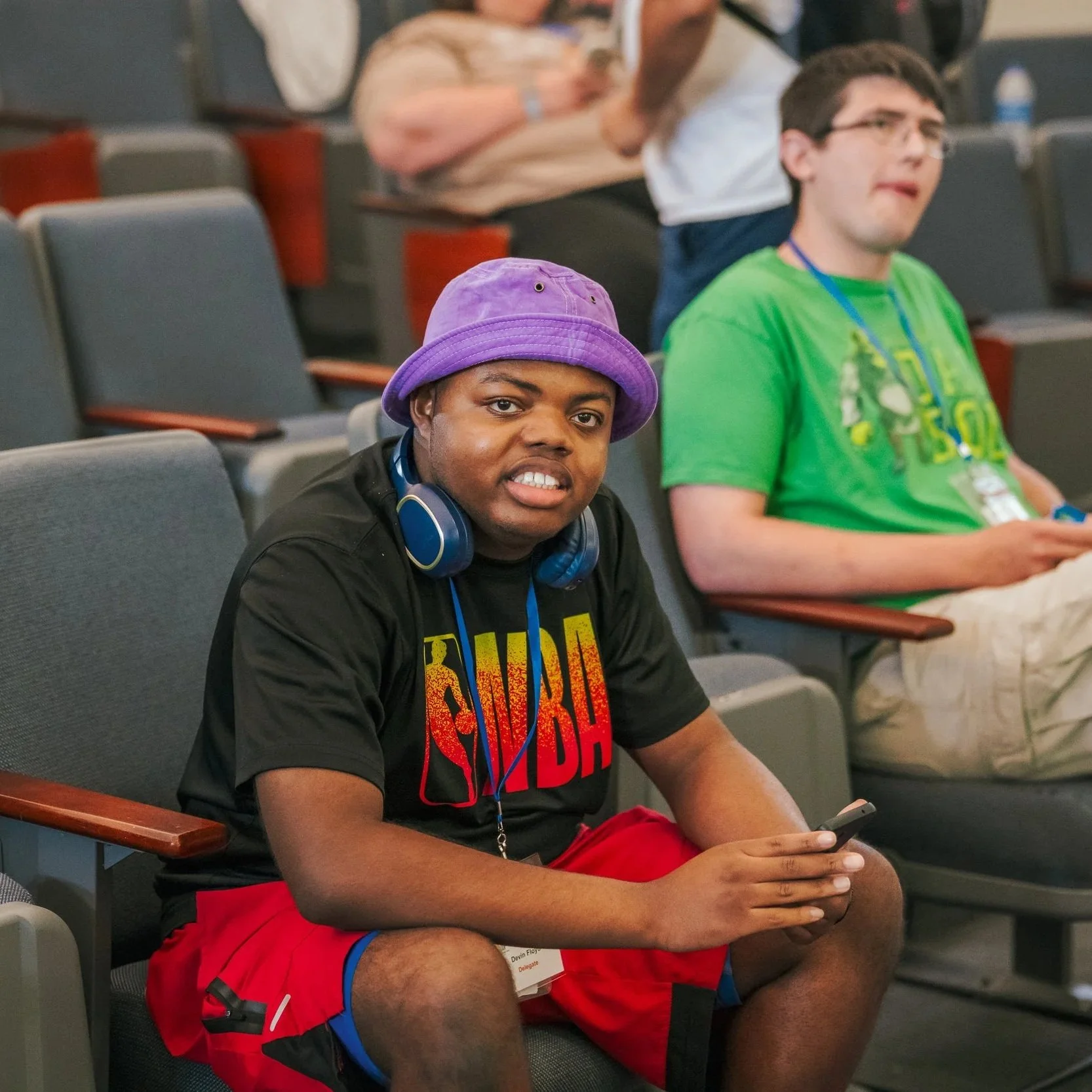  A young adult Black man with developmental disability smiles. 
