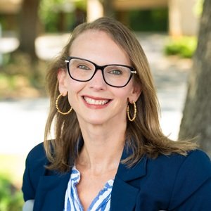 Kimberly Tissot, a white disabled woman with glasses.