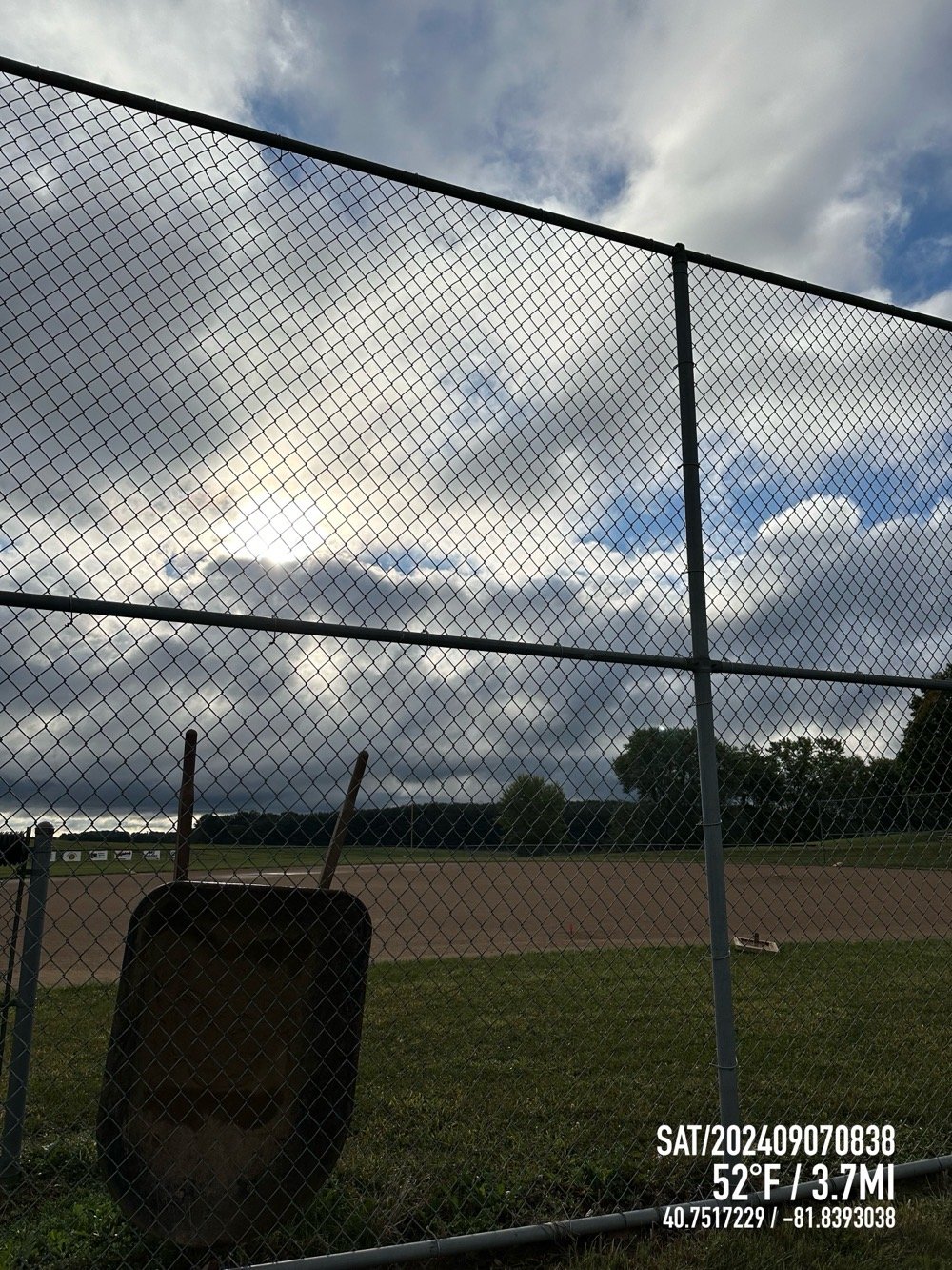 baseball field with wheelbarrow against cage