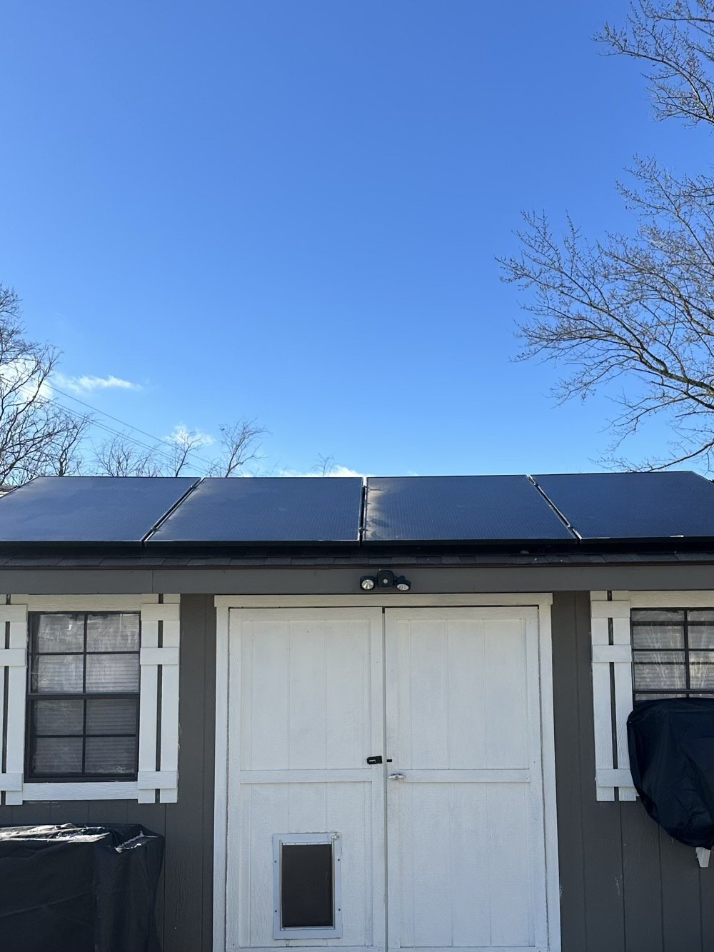 shed with solar panels, blue skies