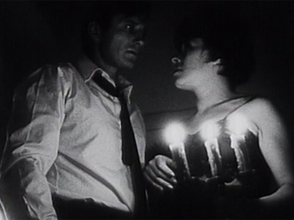 A still from Karel Kachyna's THE EAR: leads Brzobohaty and Bohdalova look at one another with dread by candlelight